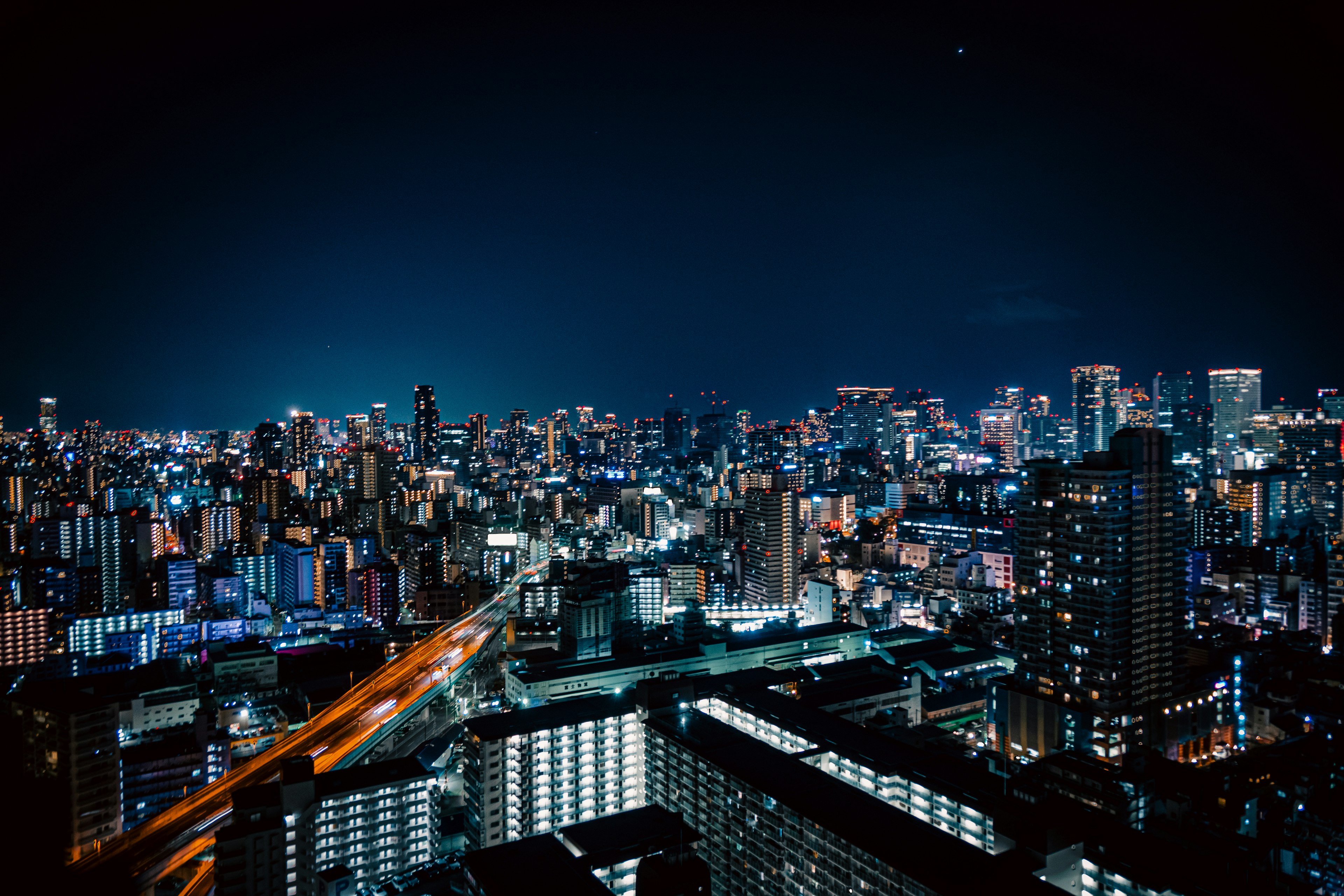 Night view of a city skyline with illuminated skyscrapers and streets