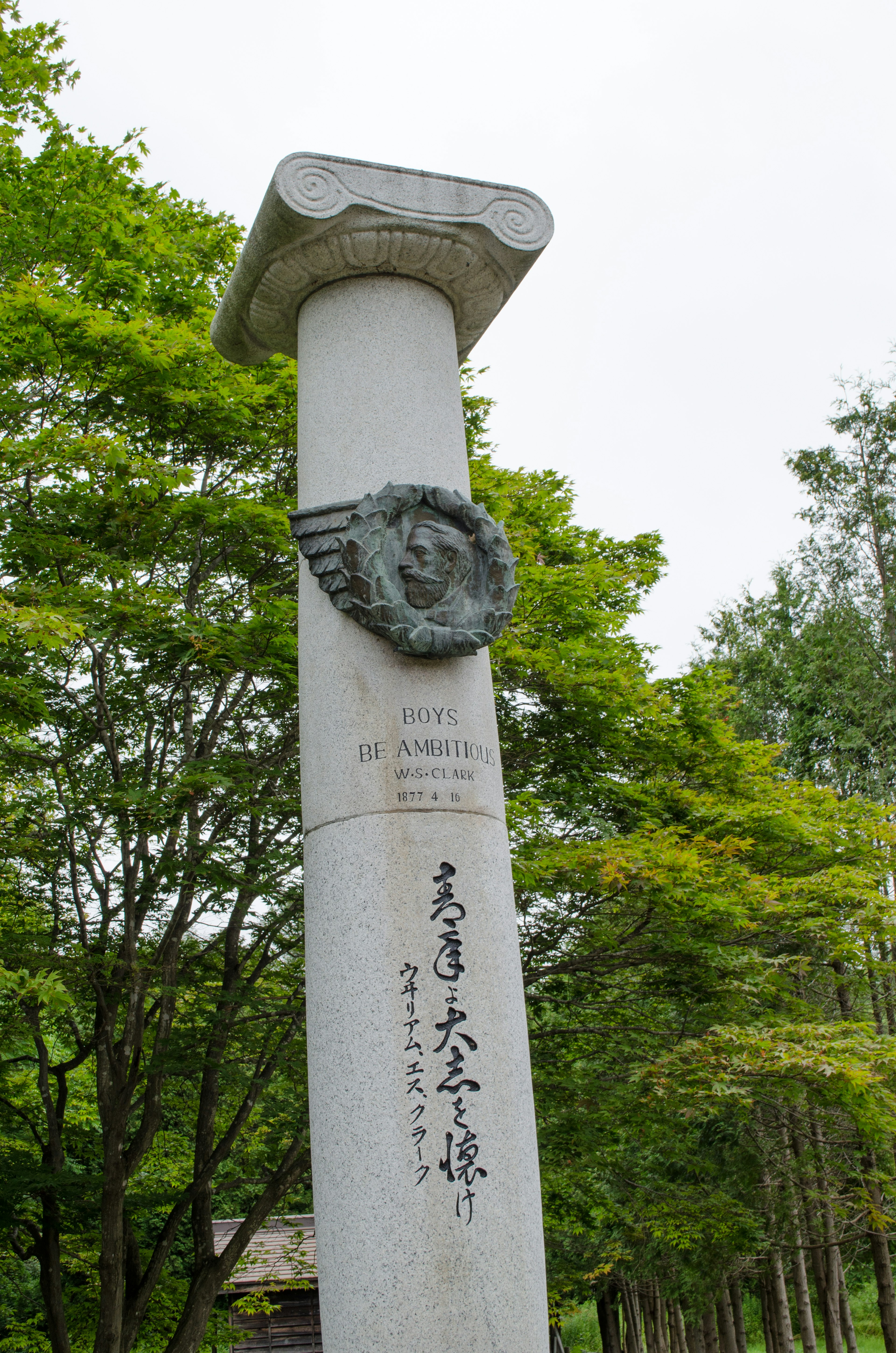 Weißer Steinpfeiler mit einer geschnitzten Gesichts und japanischem Text