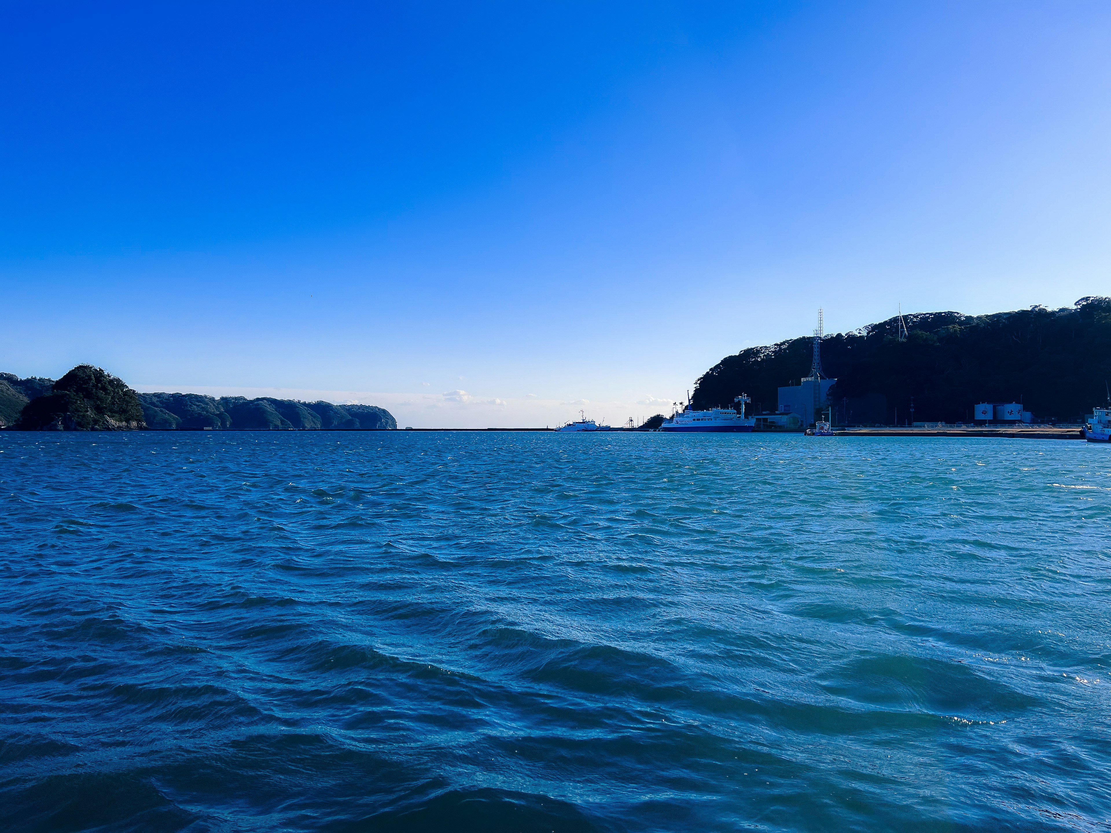 蓝色水域的风景，宁静的天空远处可见岛屿和建筑物