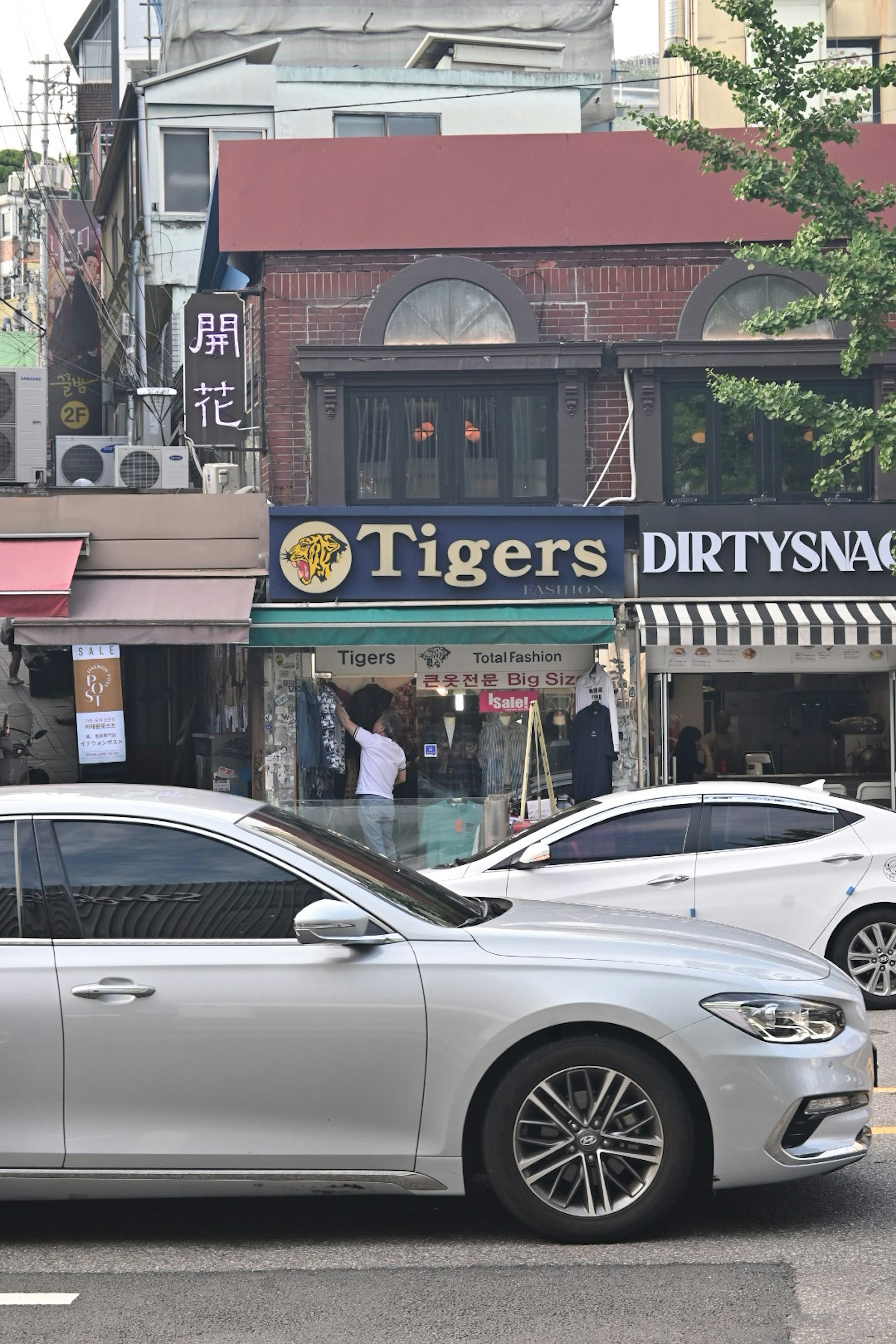 Escena callejera con el letrero Tigers y coches estacionados