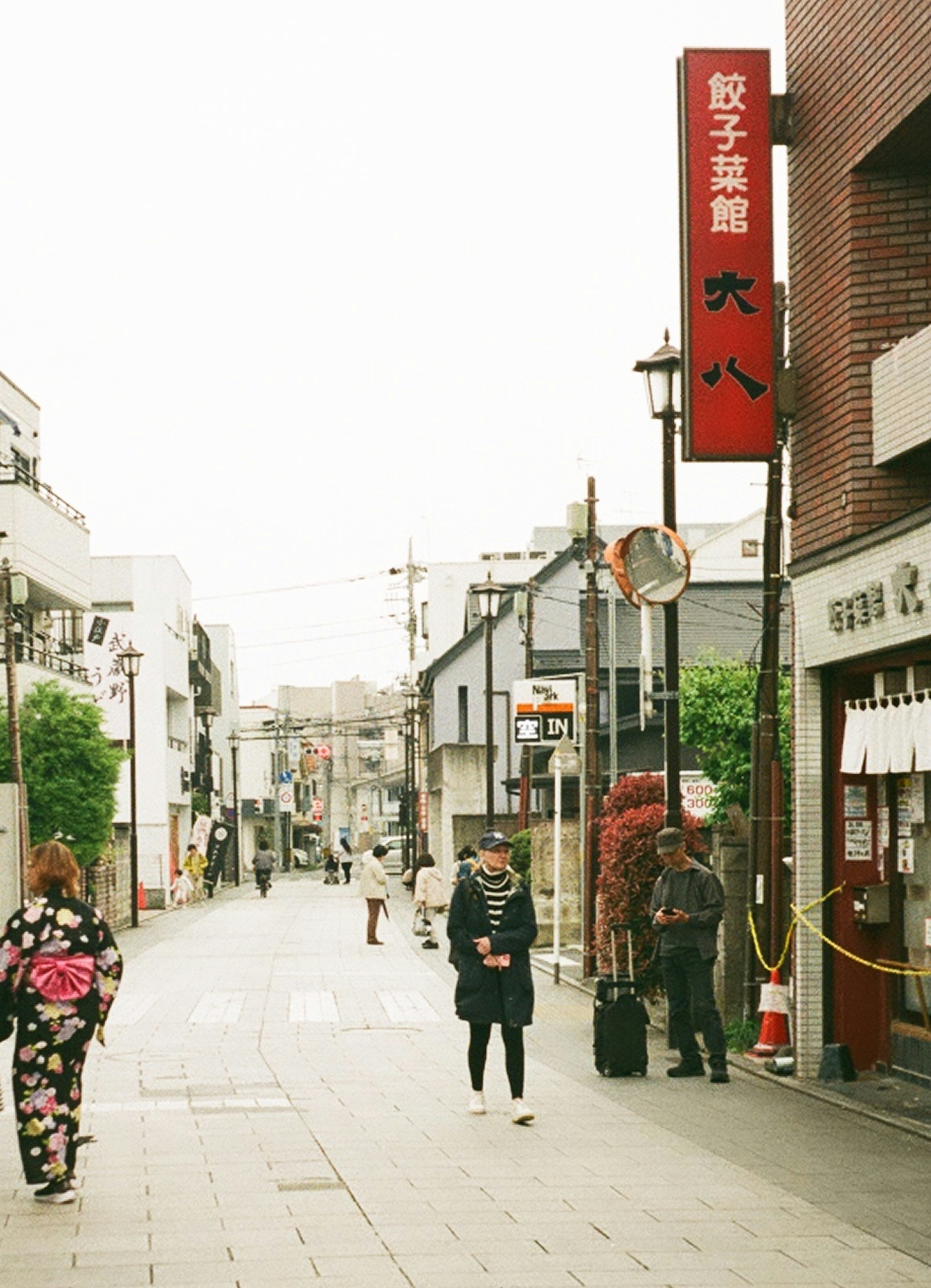 賑やかな通りに立つ人々と日本の伝統的な着物