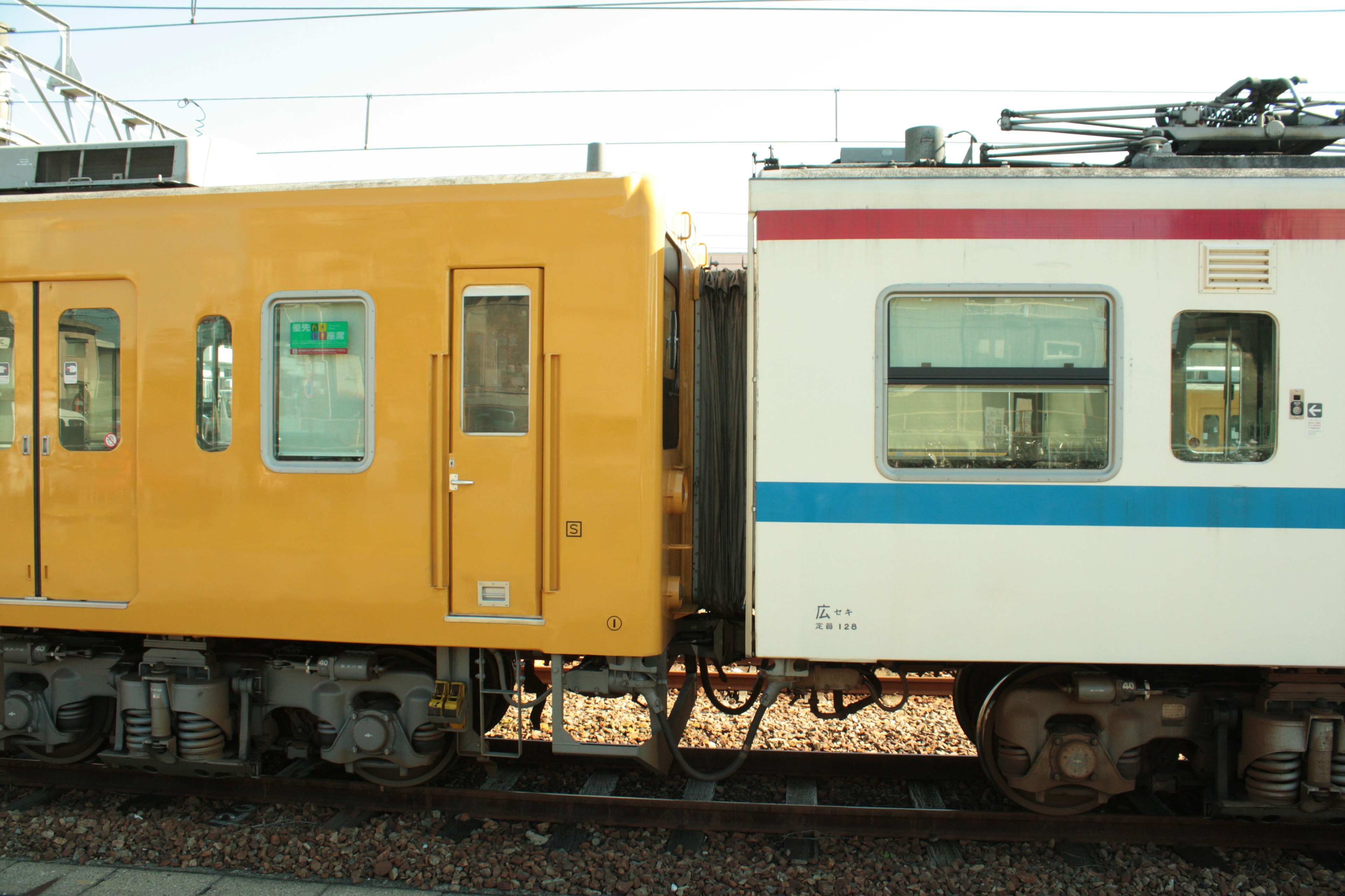 Close-up of a yellow train and a white train connected