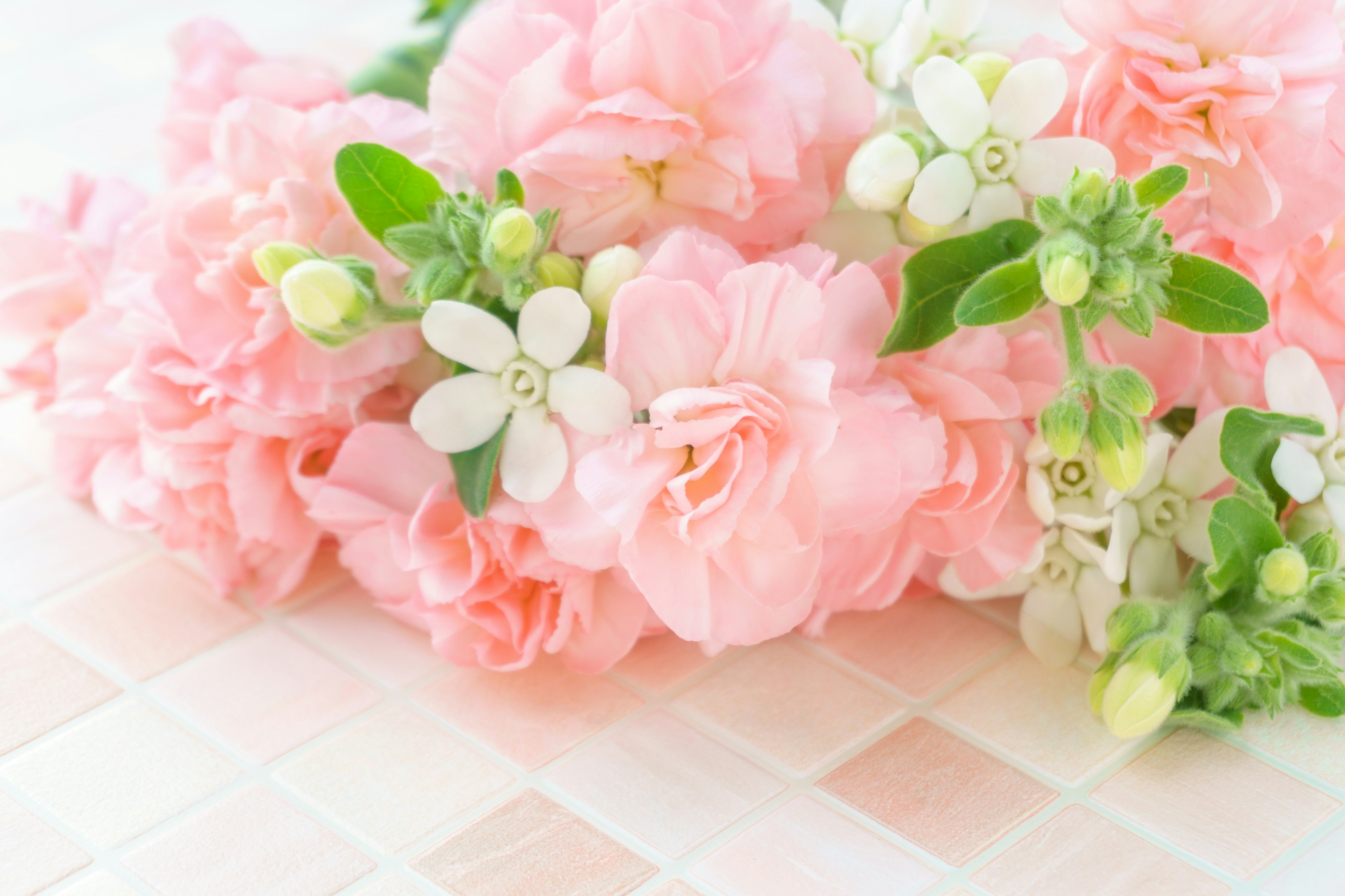 Un ramo de flores rosas y blancas arreglado sobre una mesa