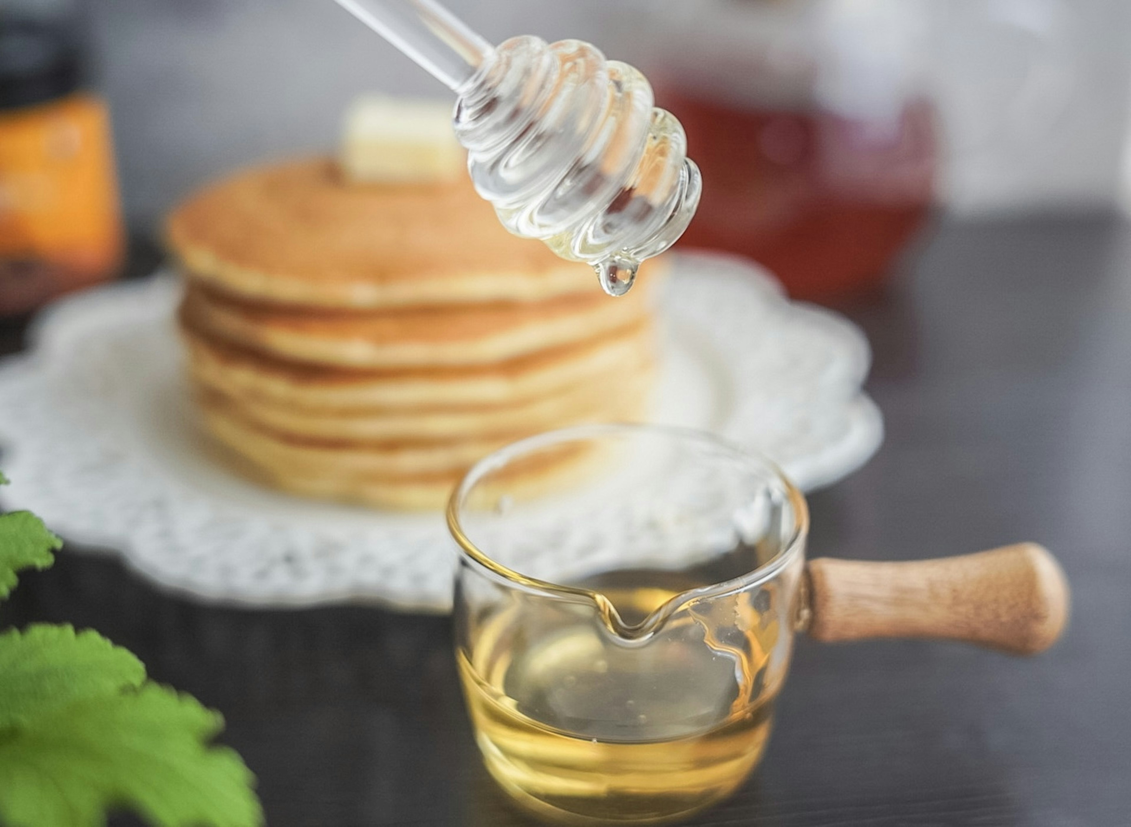 Cảnh bữa sáng đơn giản với bánh pancake và mật ong trên bàn