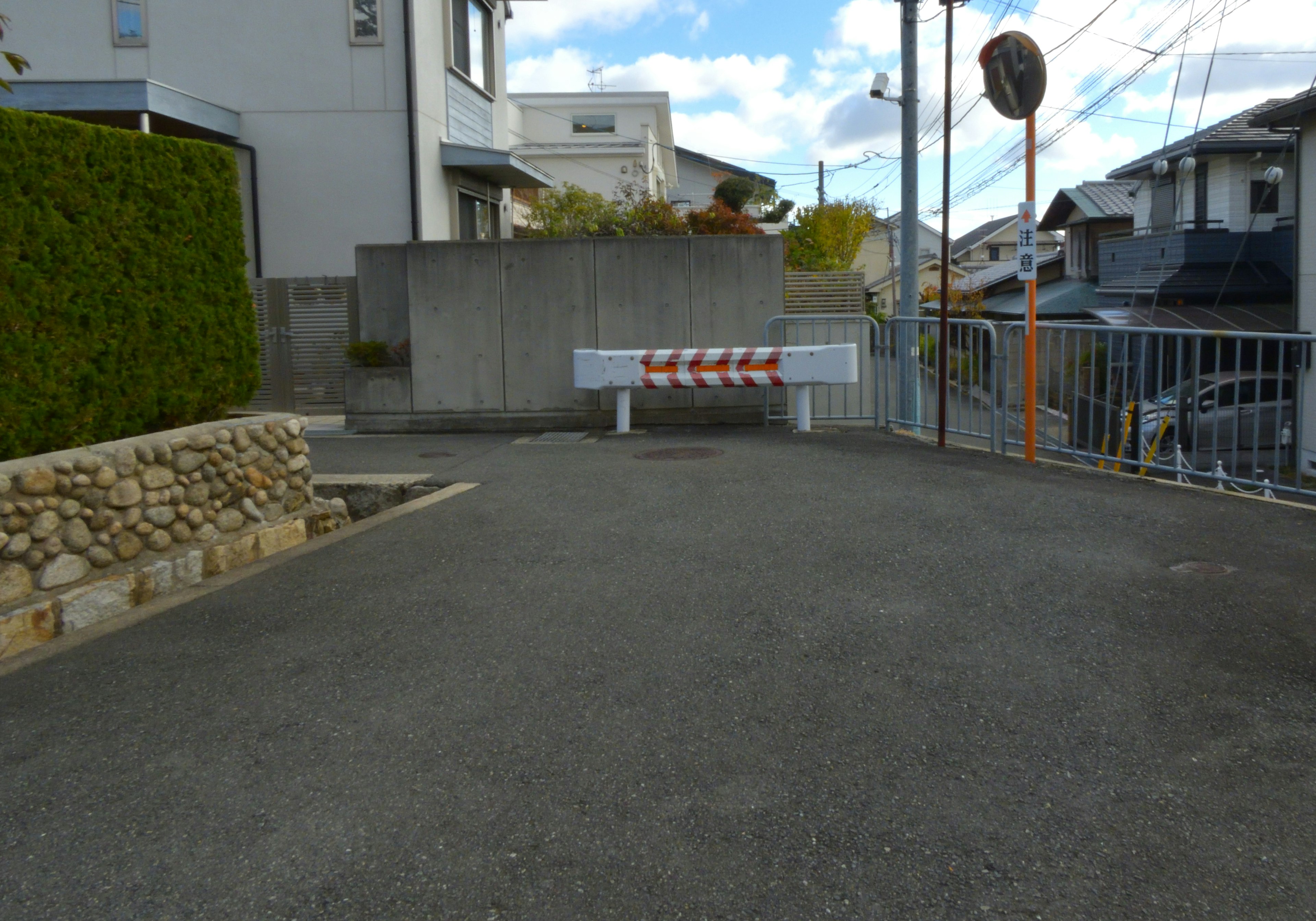 A vacant lot in a residential area featuring a barrier and blue sky