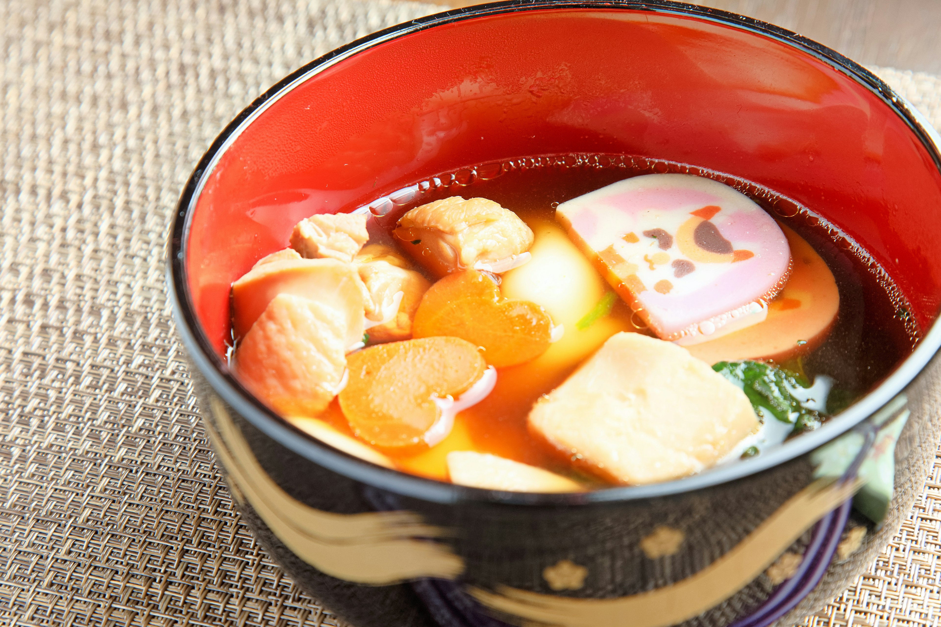 Sopa de miso servida en un tazón rojo con varios ingredientes