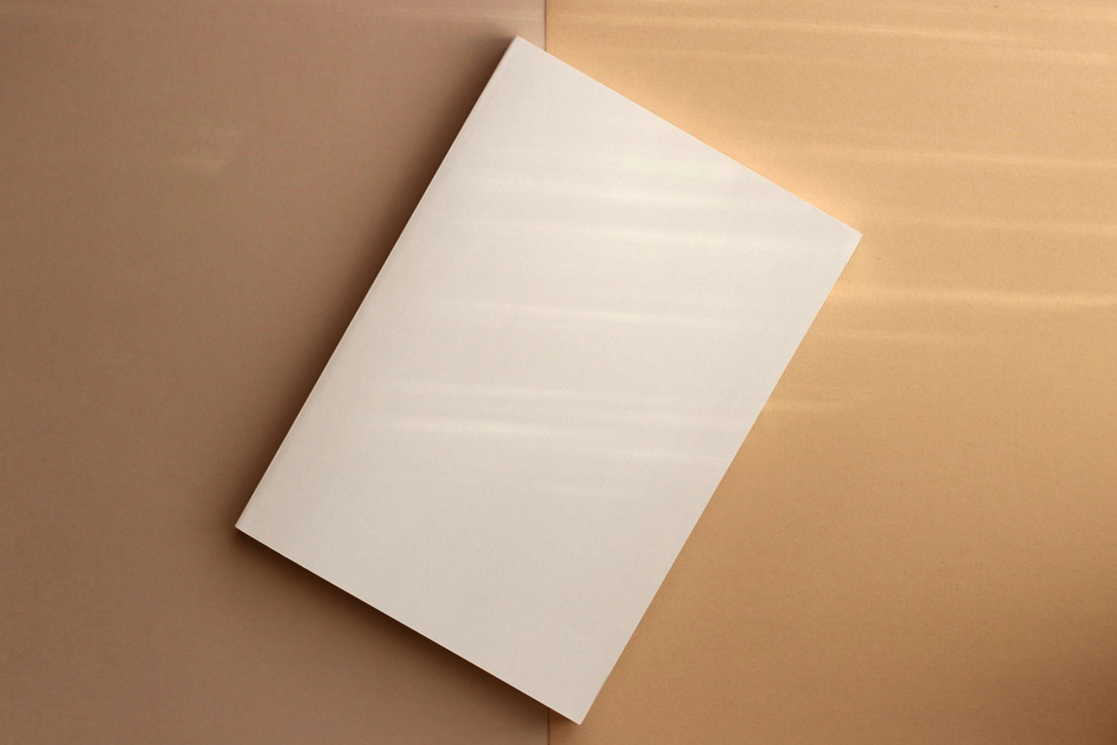 Plain white notebook on a brown background