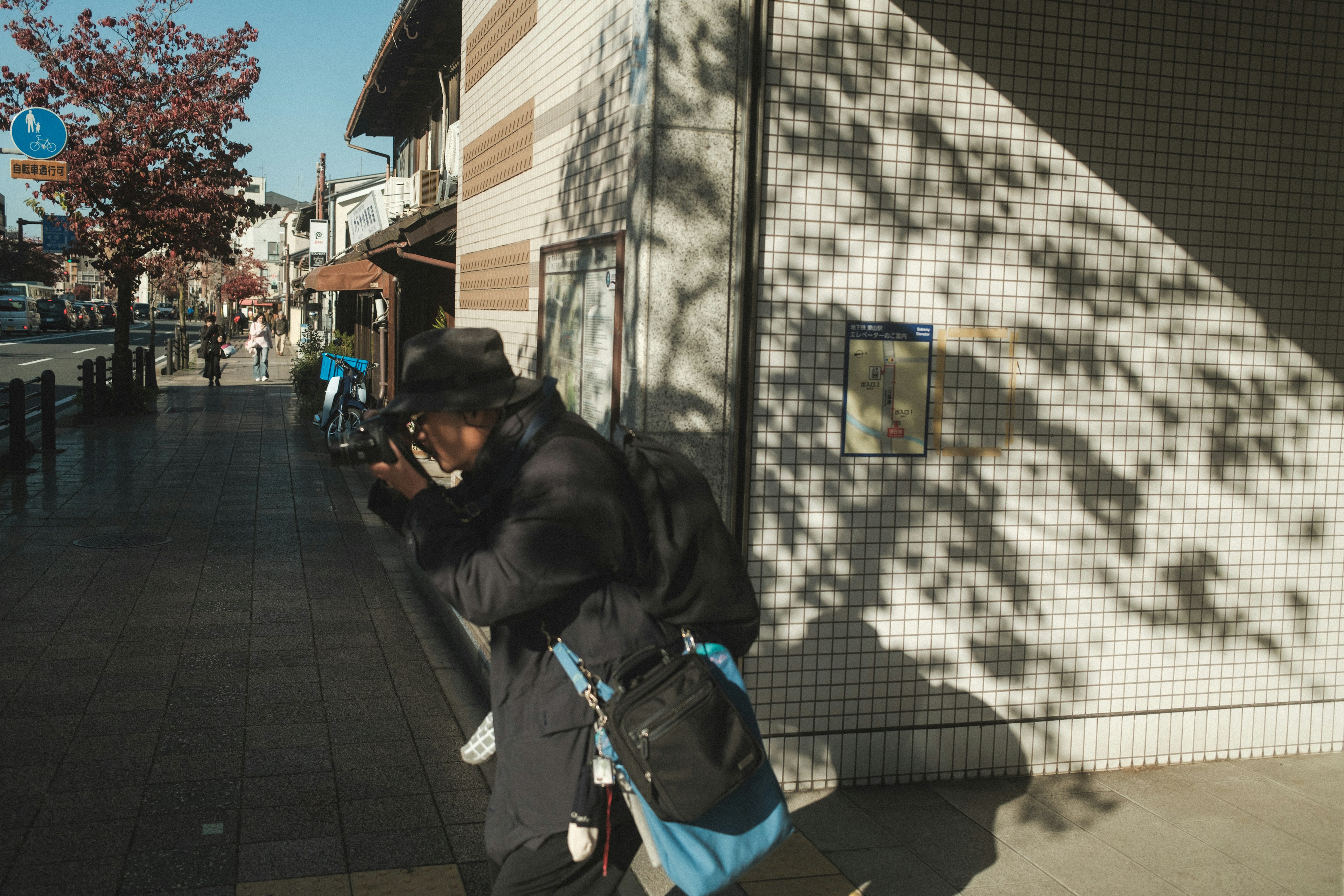 カメラを持つ人と影のある街並み