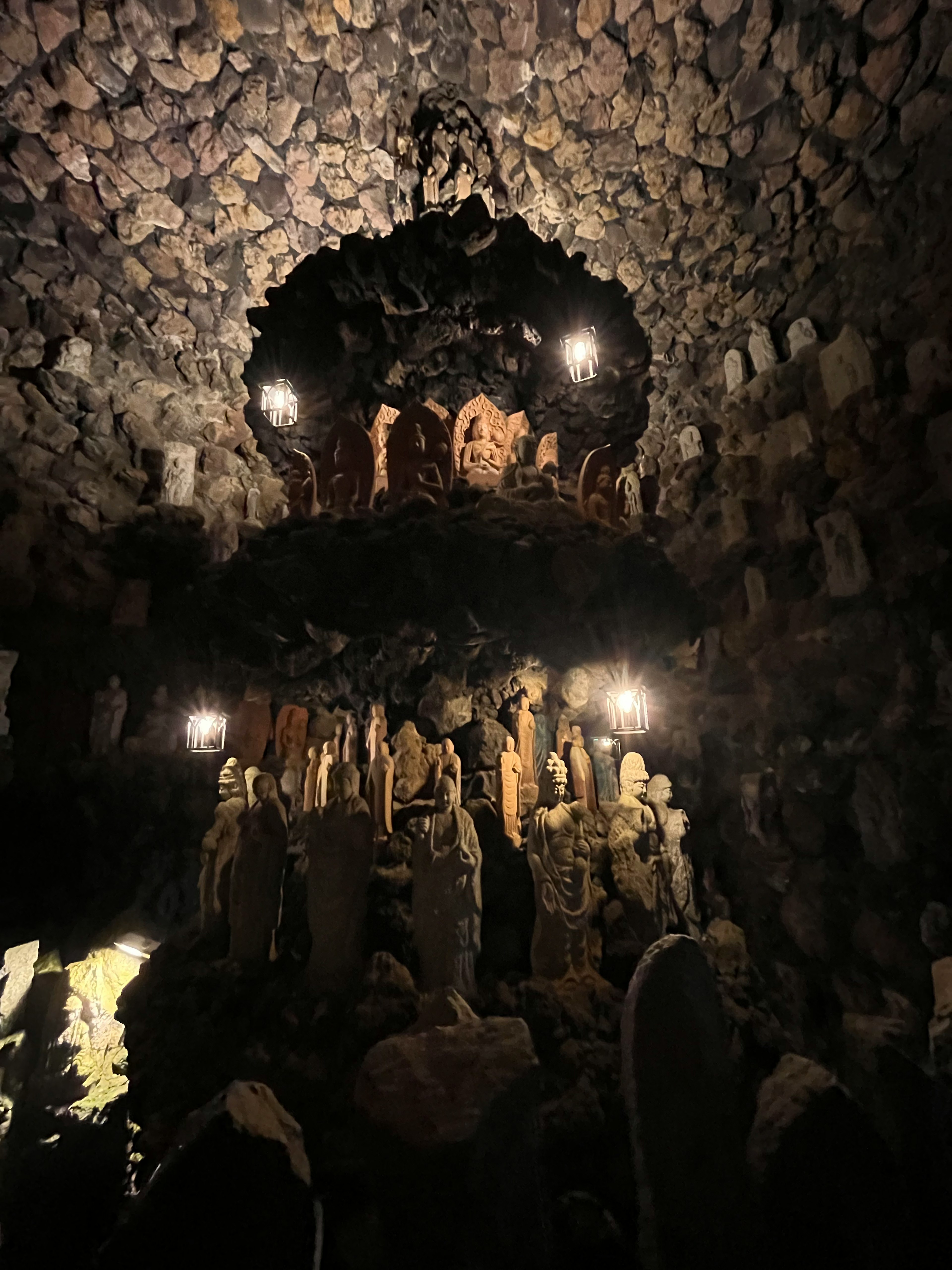 Grotte sombre avec de nombreuses sculptures et éclairage