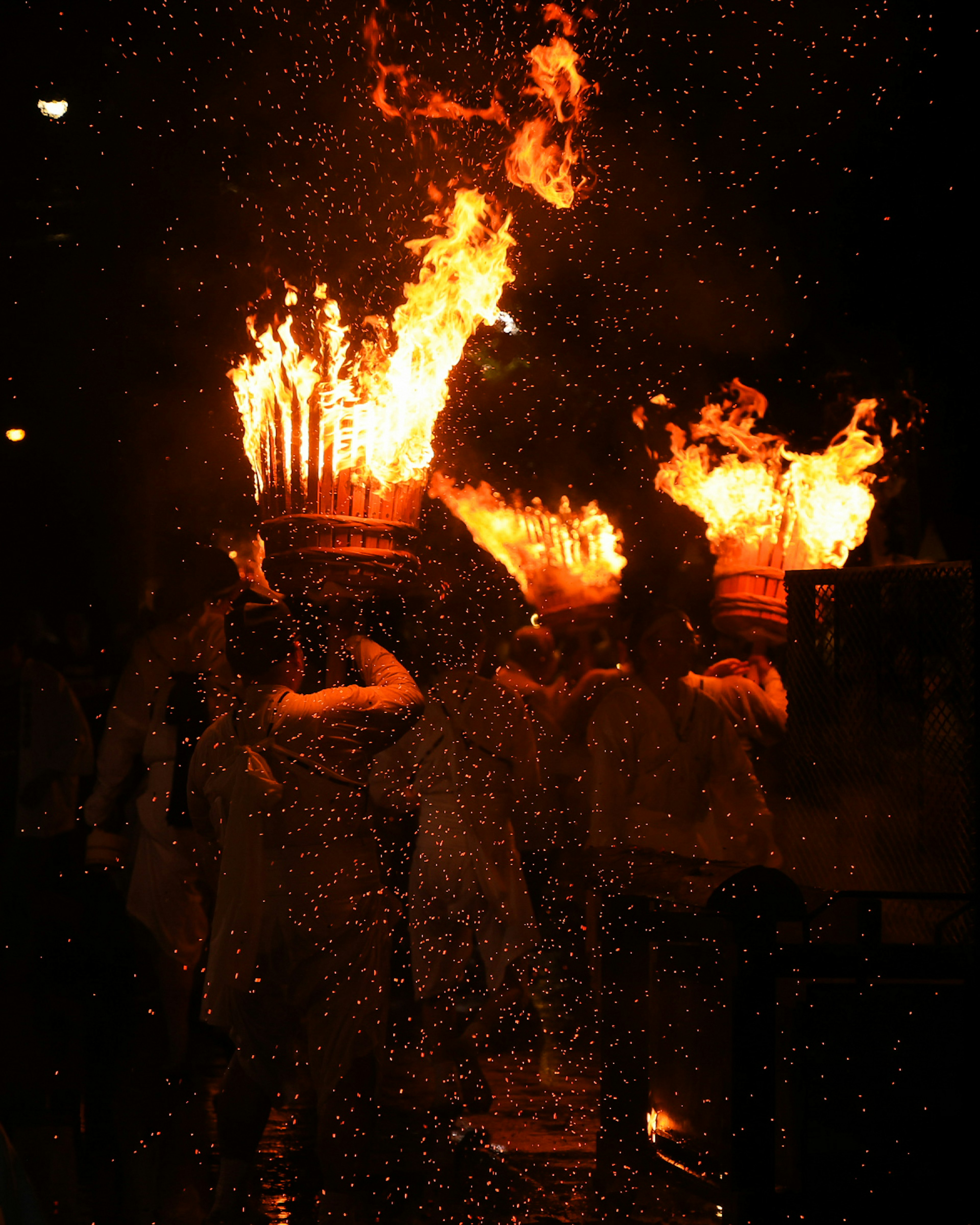 Personas celebrando un festival con antorchas en llamas