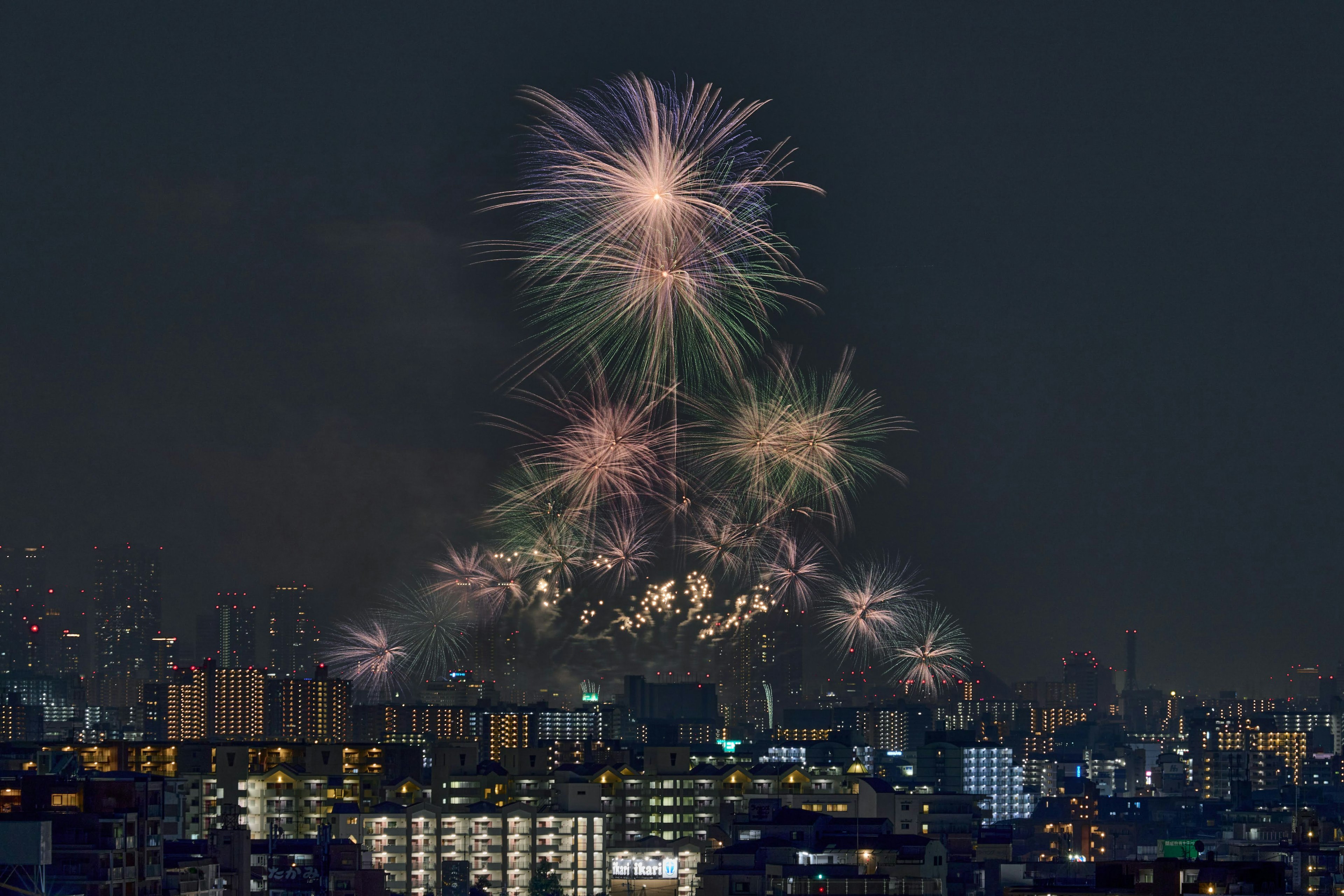 Des feux d'artifice colorés illuminant le ciel nocturne sur un paysage urbain