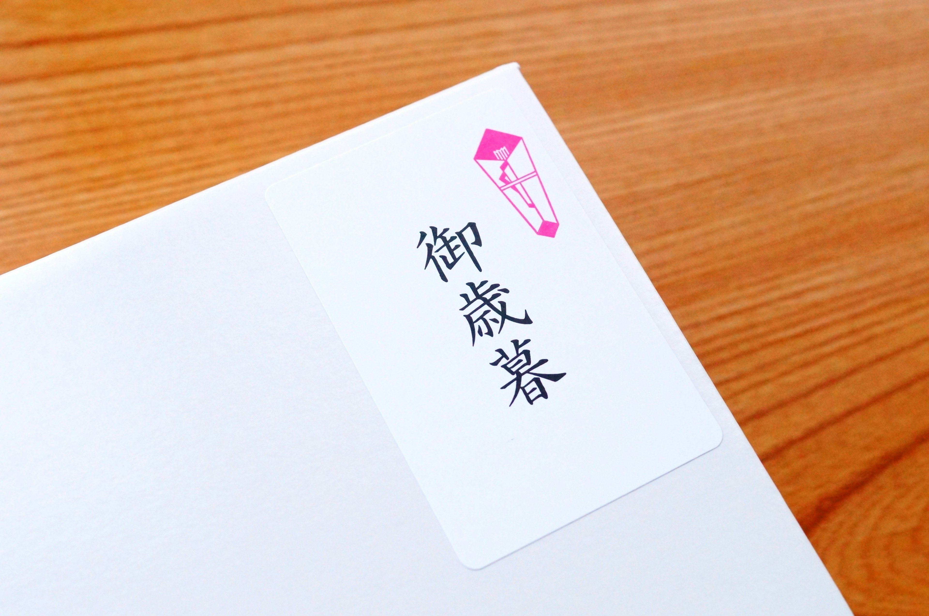 Label with Japanese characters on a white envelope featuring a pink emblem