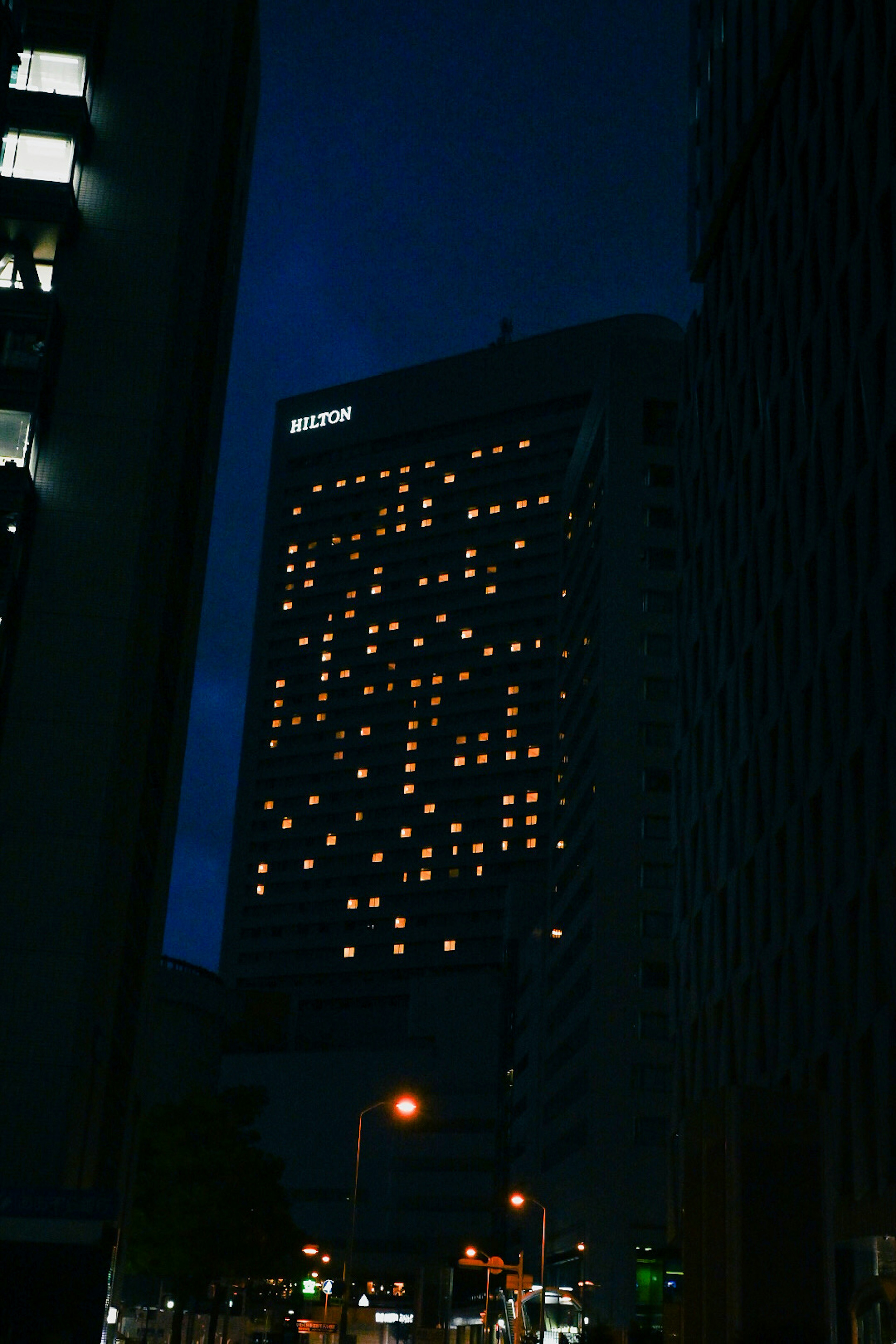 Escena nocturna de un edificio con ventanas iluminadas creando un patrón único