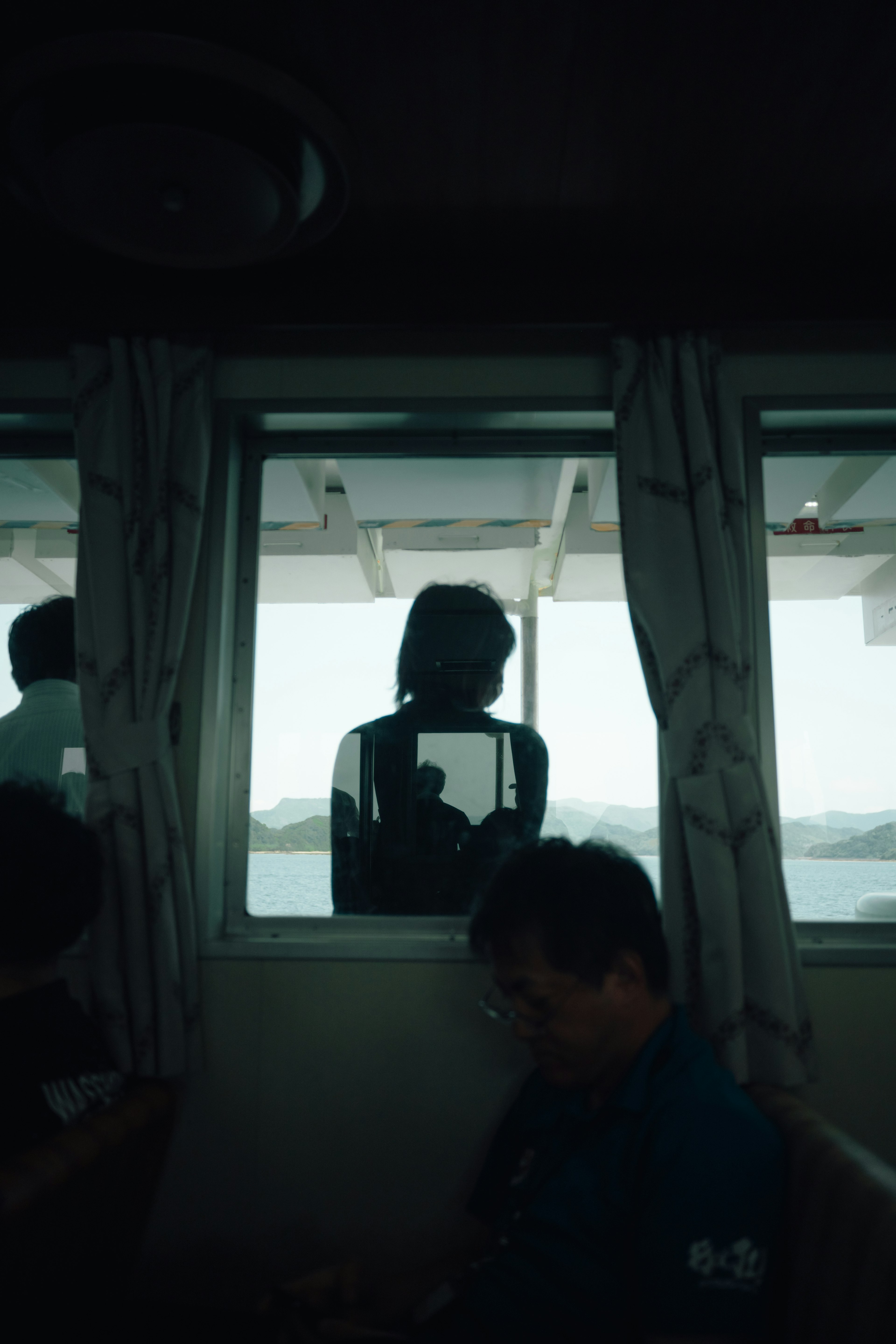 Schatten einer Frau, die aus dem Fenster auf das Meer schaut