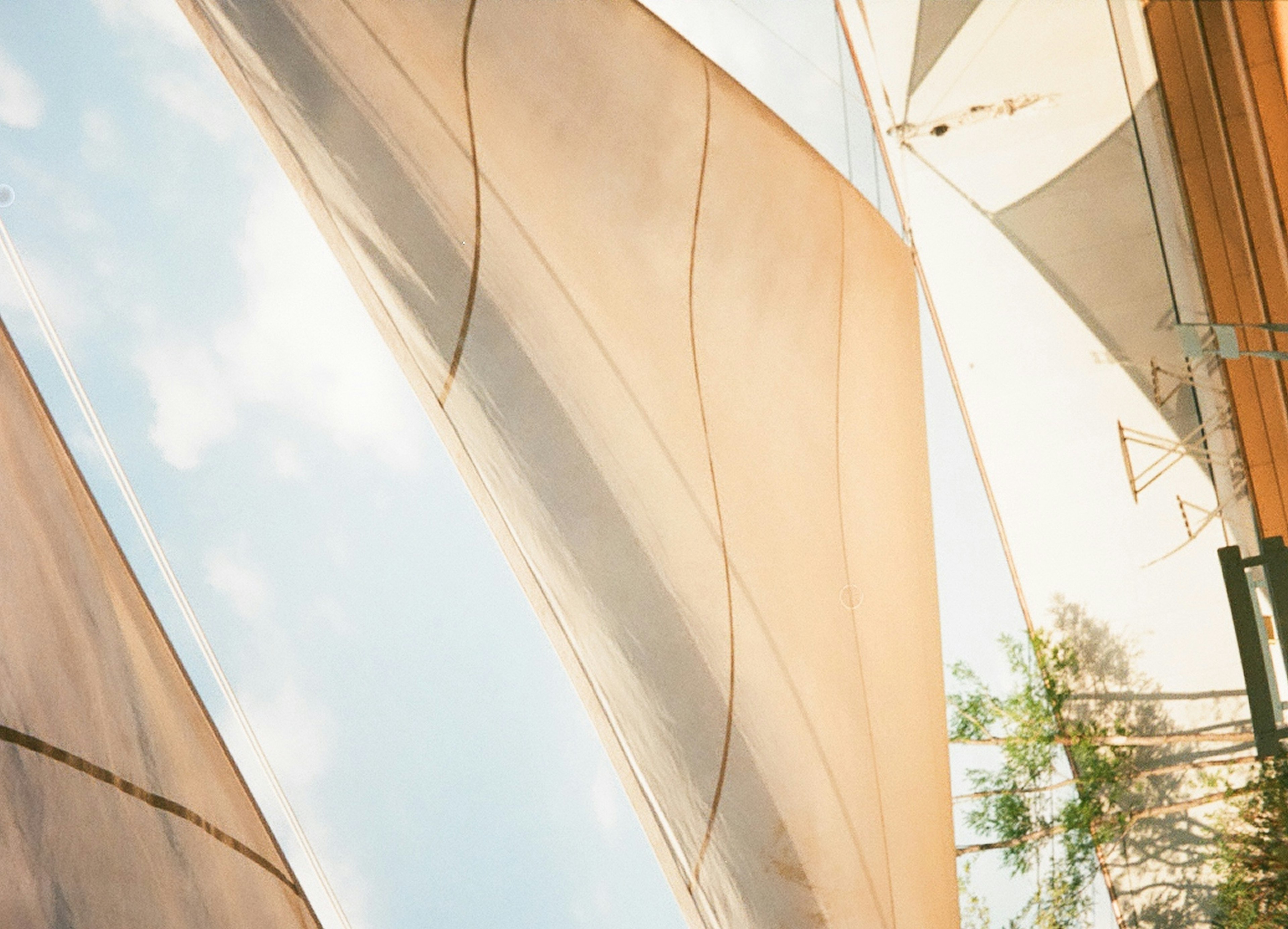 Silhouettes de voiles aux couleurs douces sous un ciel bleu