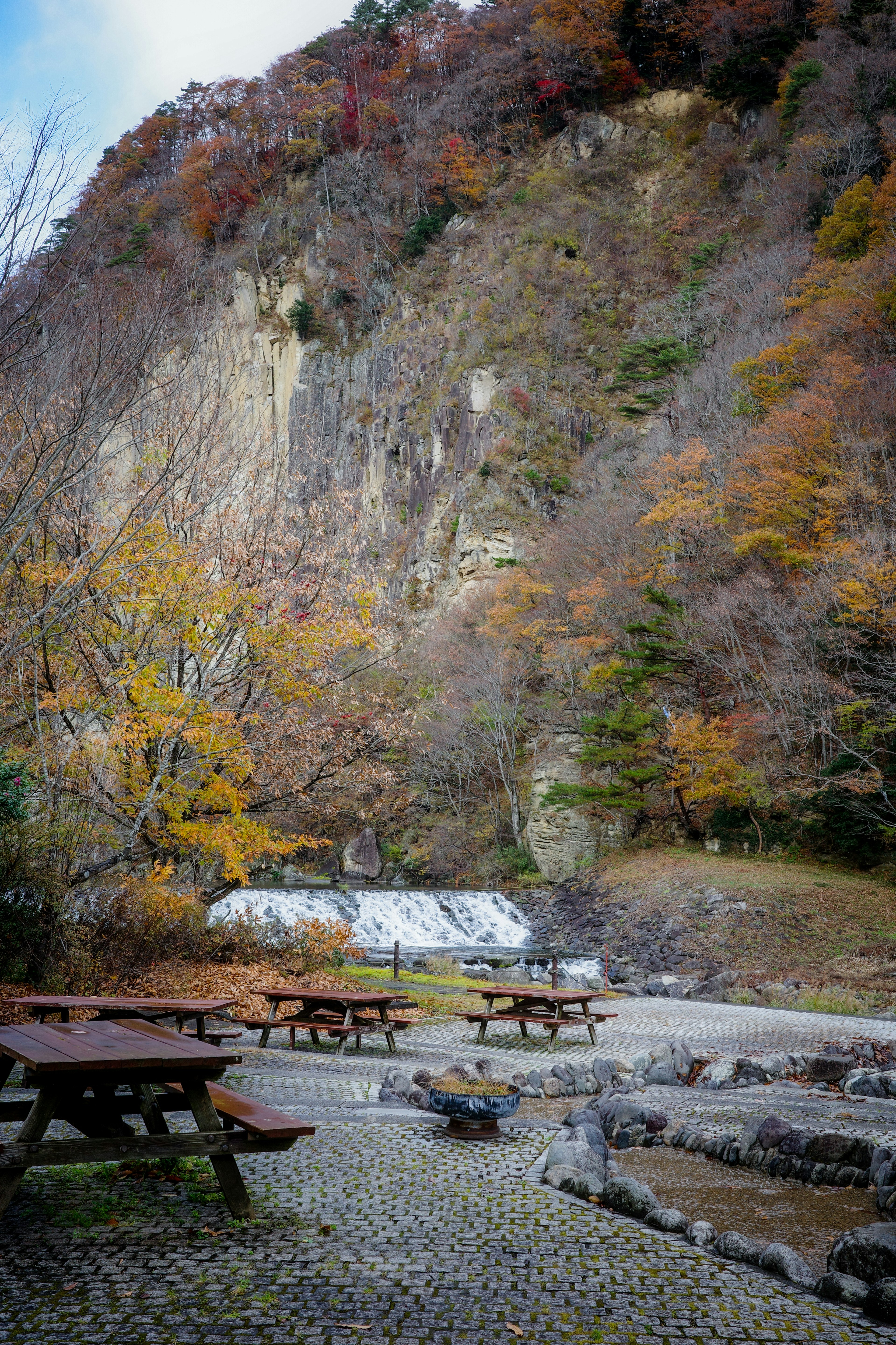 Malersches Herbstlandschaft mit Holztischen