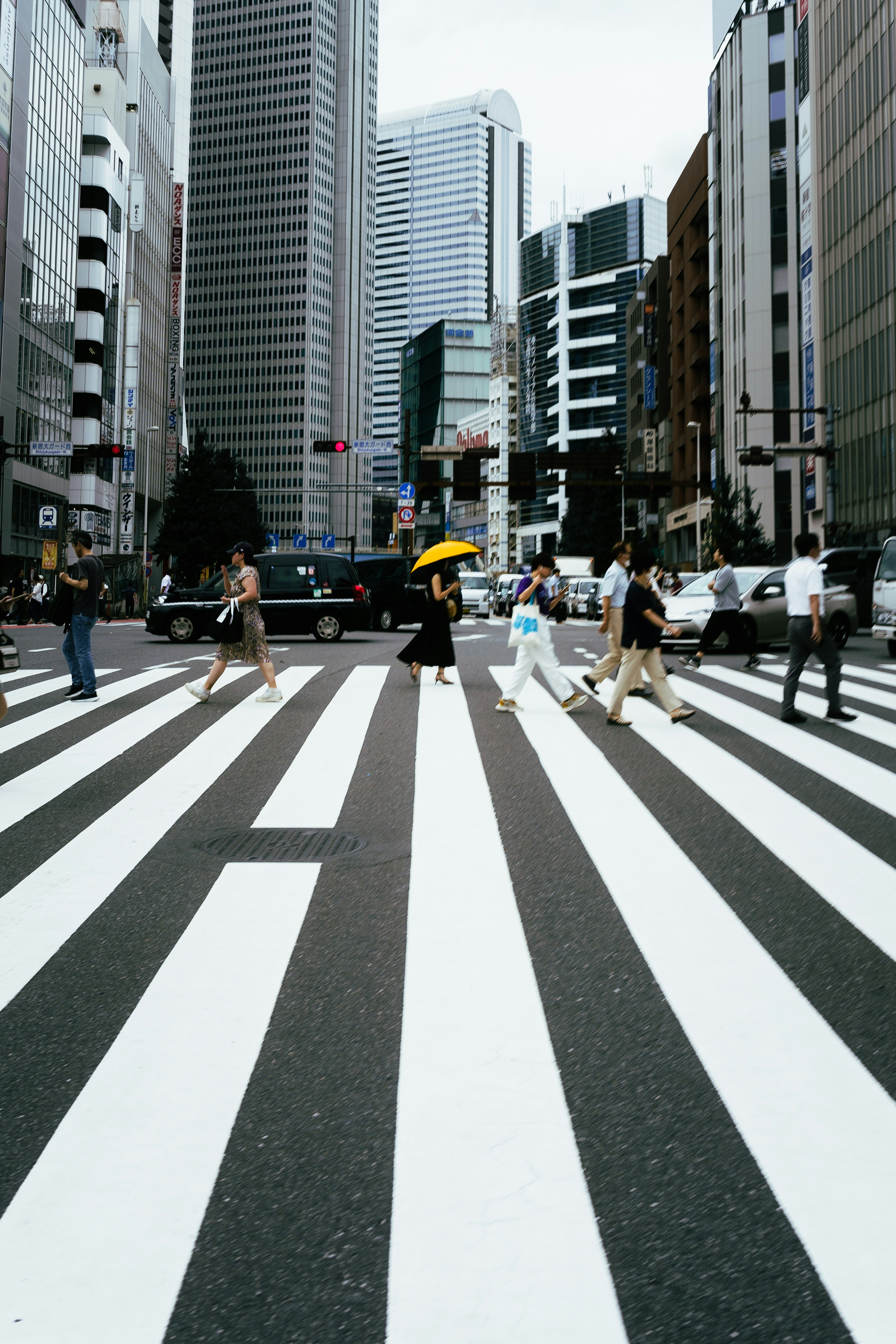 People crossing a zebra crossing in an urban setting with modern buildings