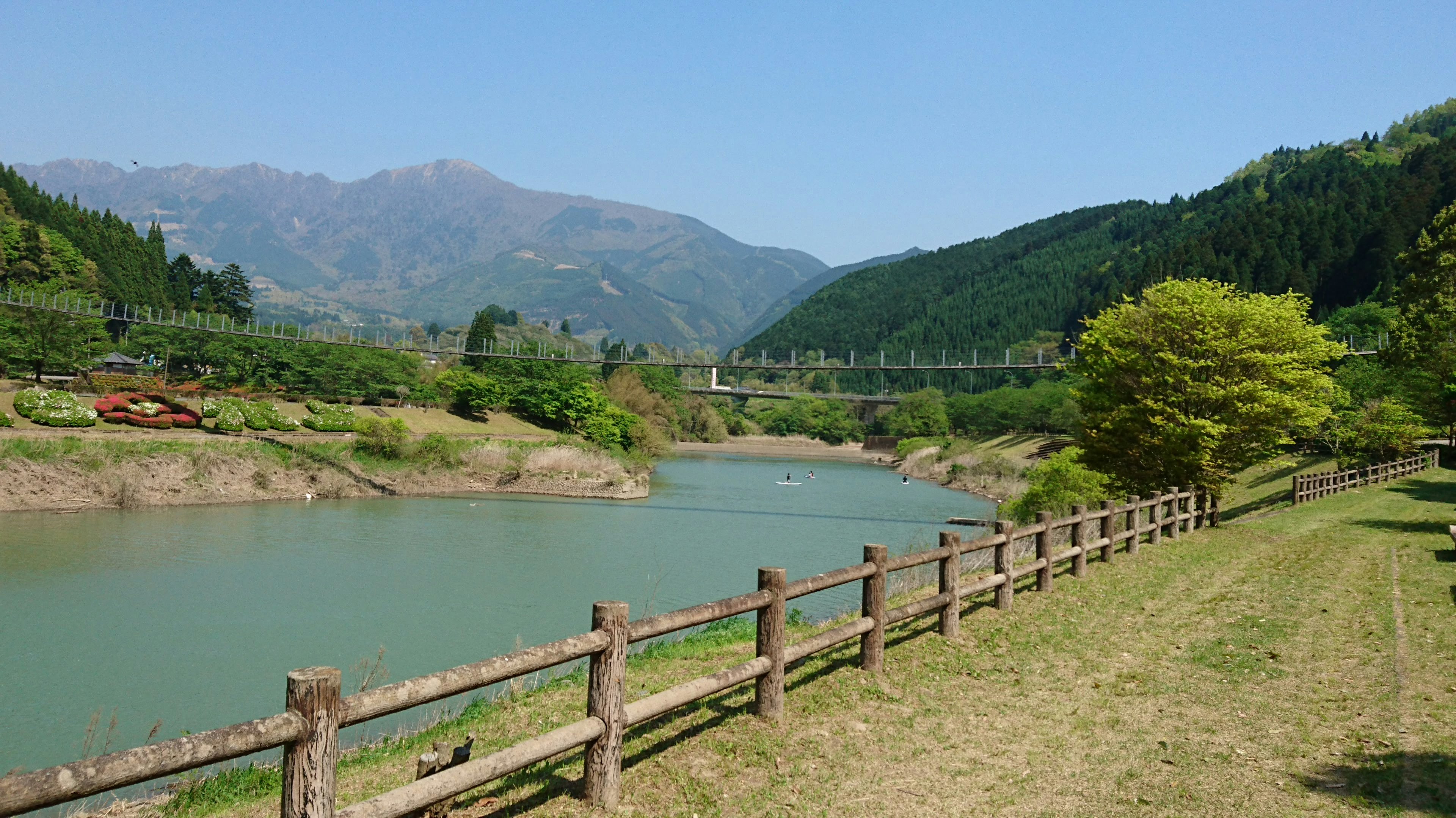 Scenic view of a calm river surrounded by green mountains