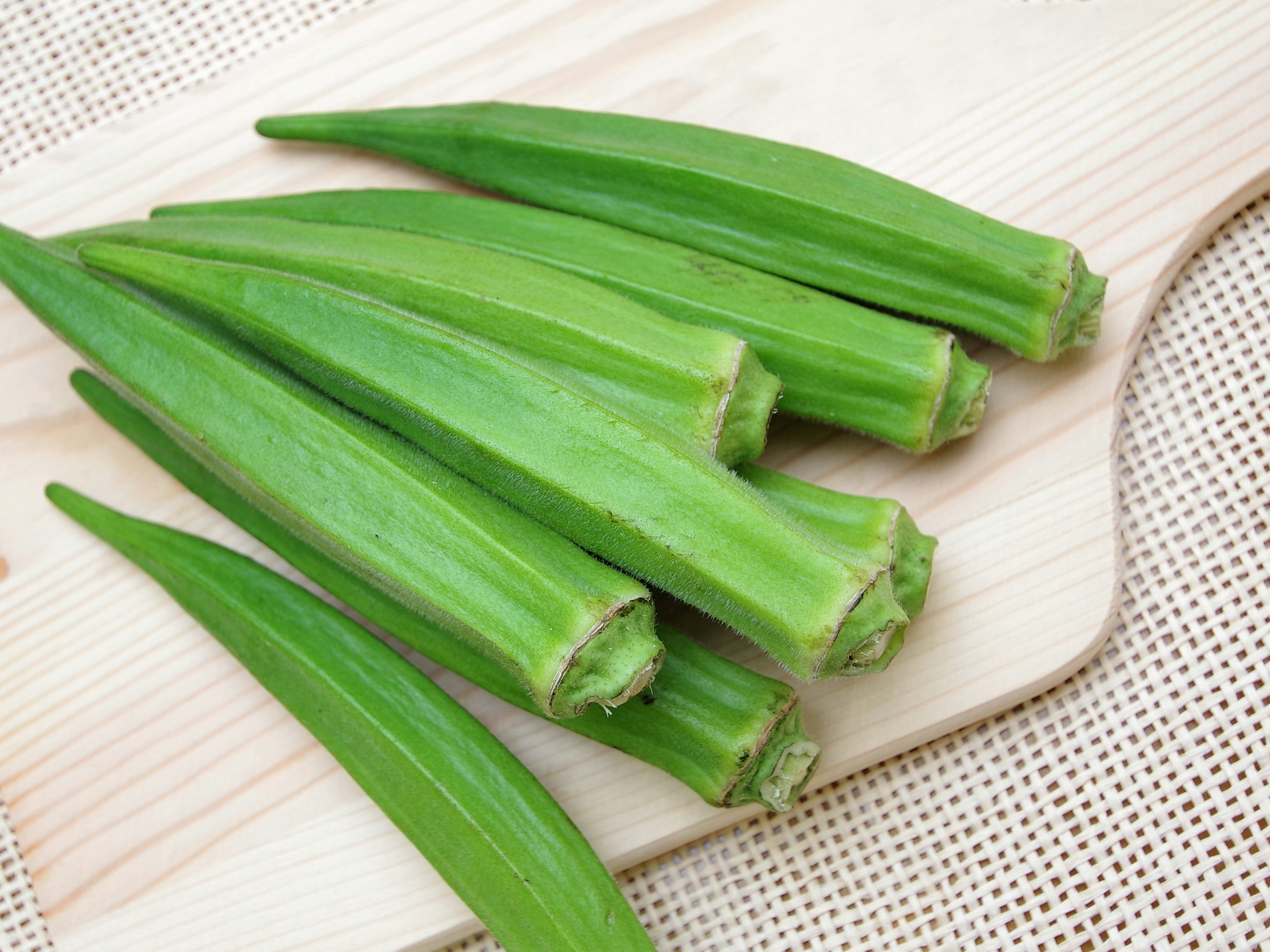 Okra fresca dispuesta sobre una tabla de madera