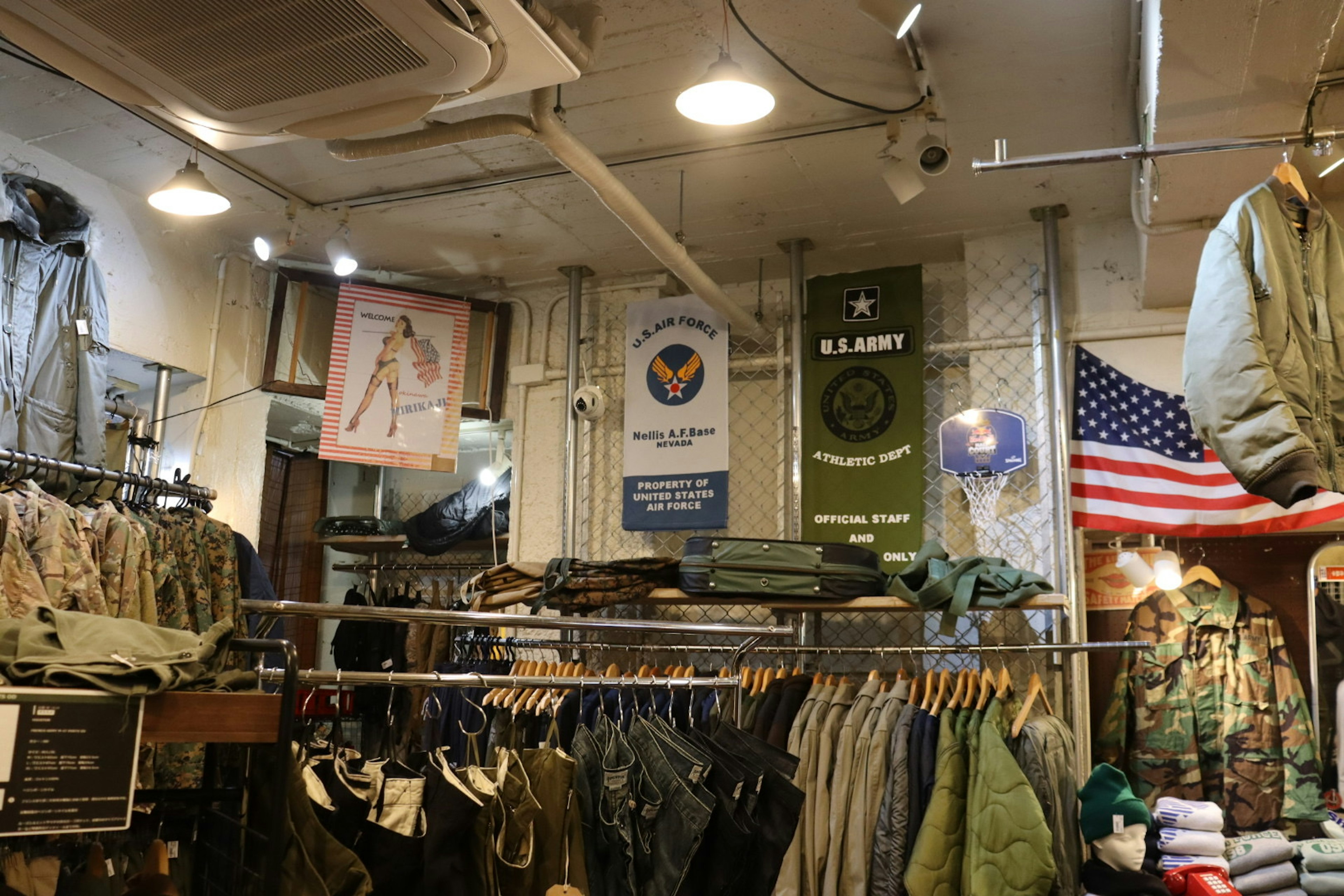 Interior of a military clothing store with various uniforms and banners including the American flag