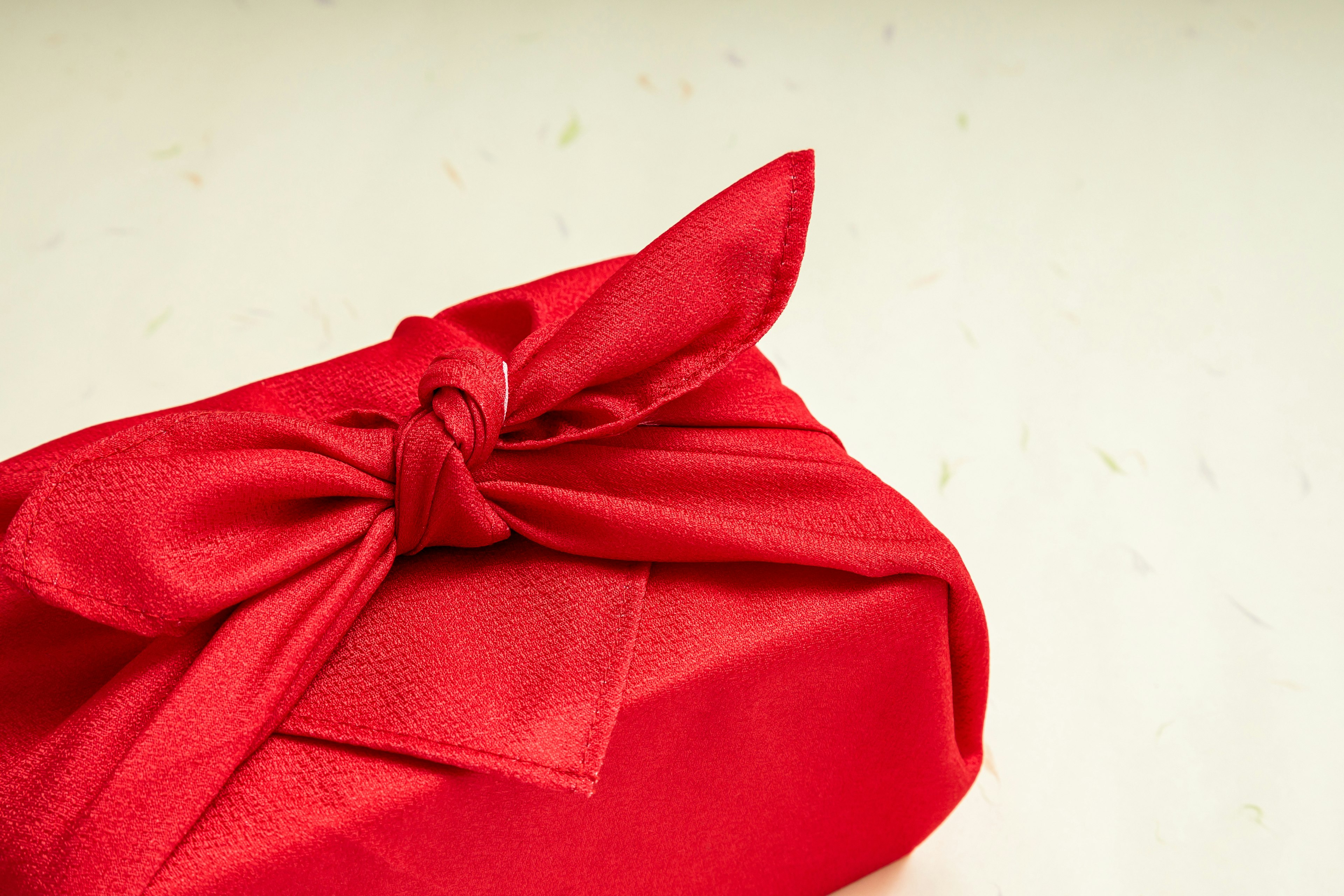 A red fabric-wrapped gift with a bow