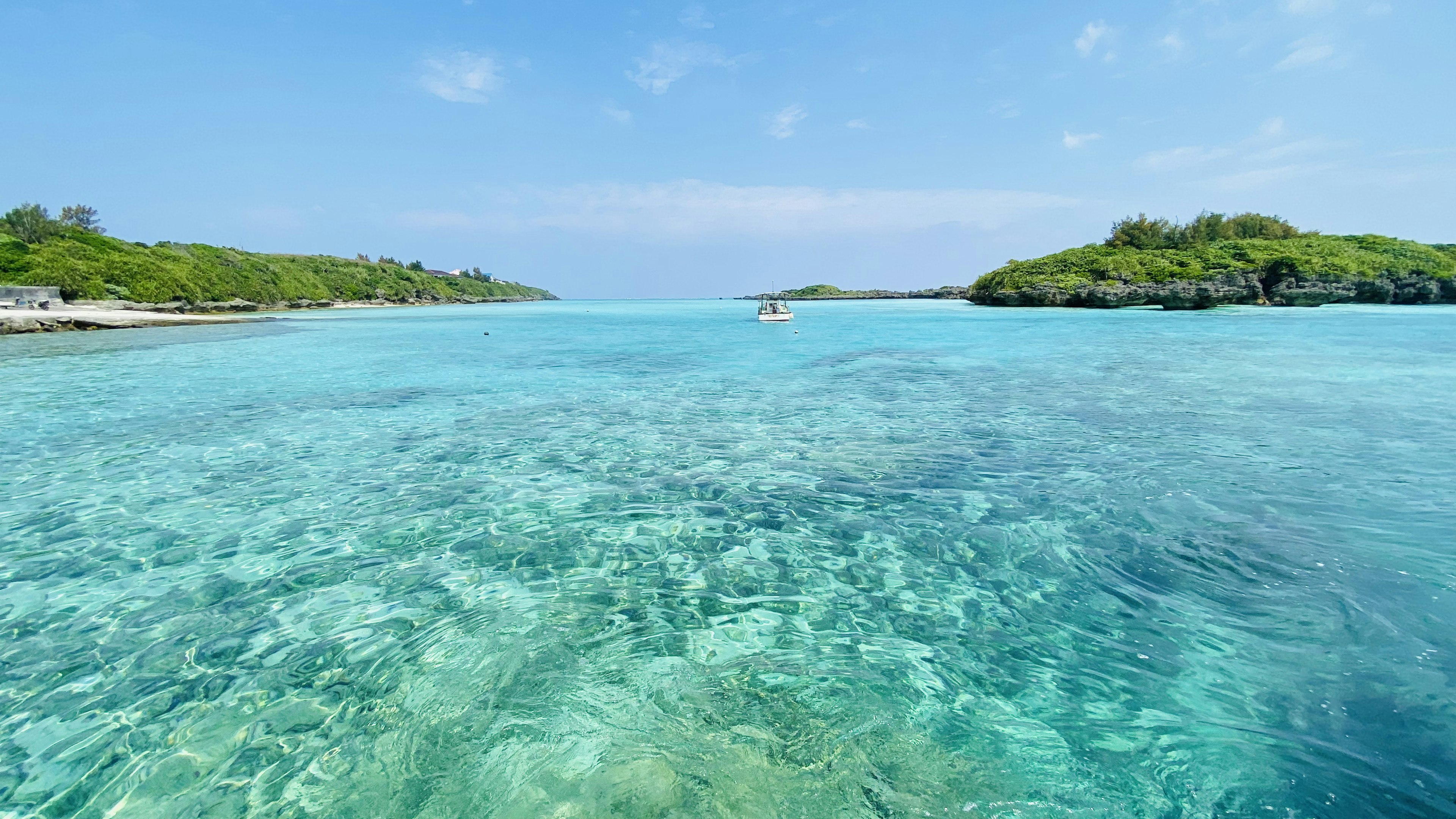 Clear turquoise water with green islands in the background