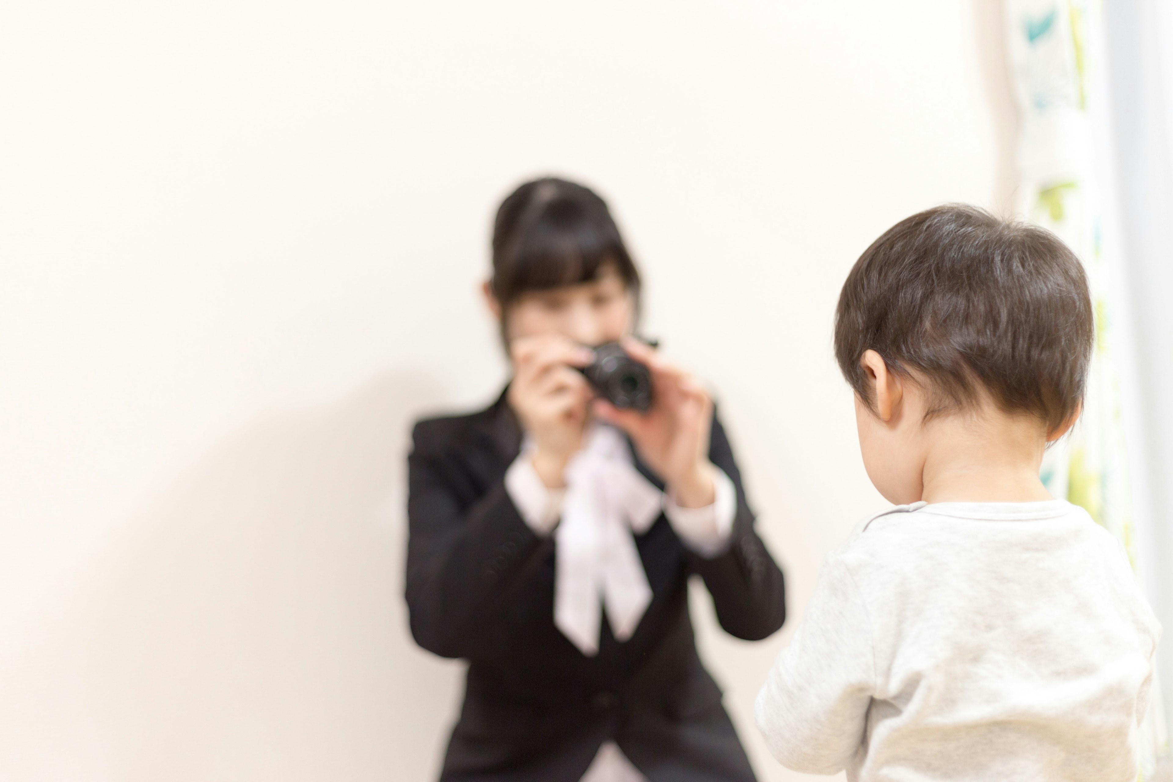 카메라를 든 여성이 아이의 뒷모습을 촬영하는 장면