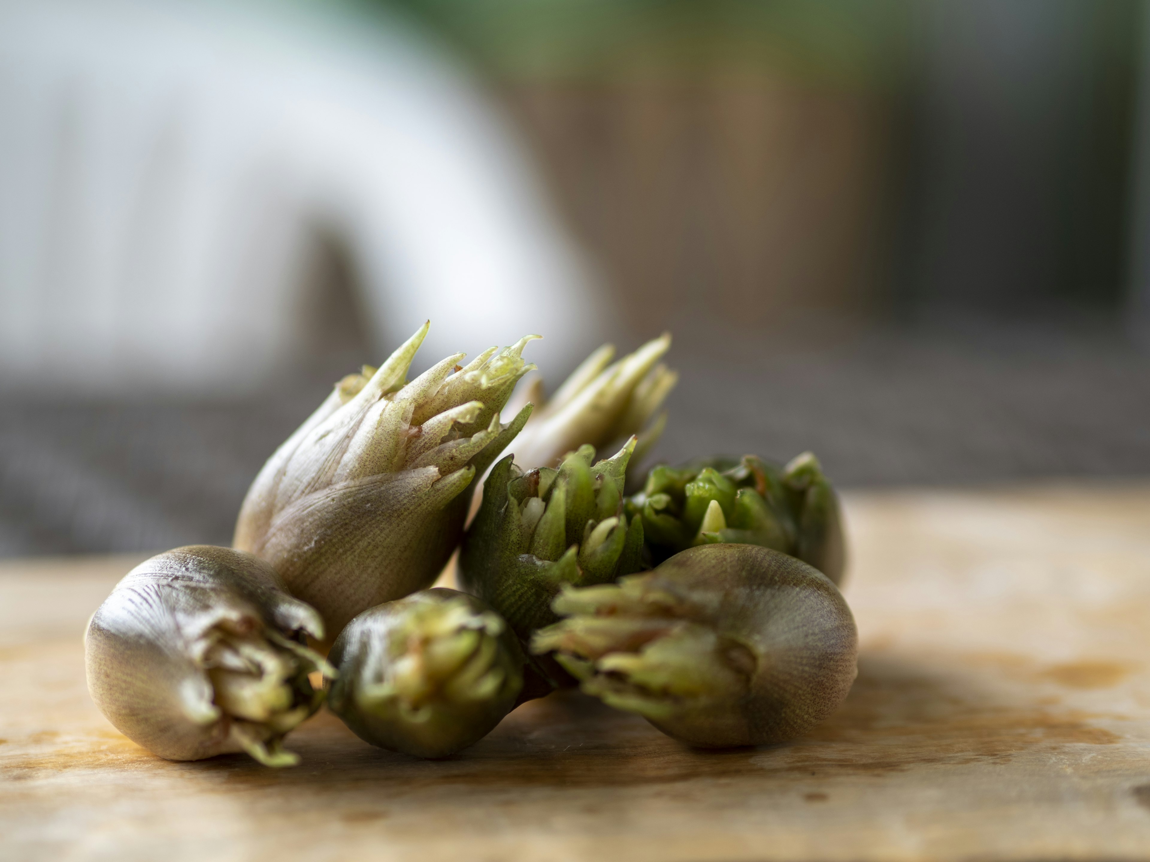 Fresh artichoke buds arranged on a wooden board