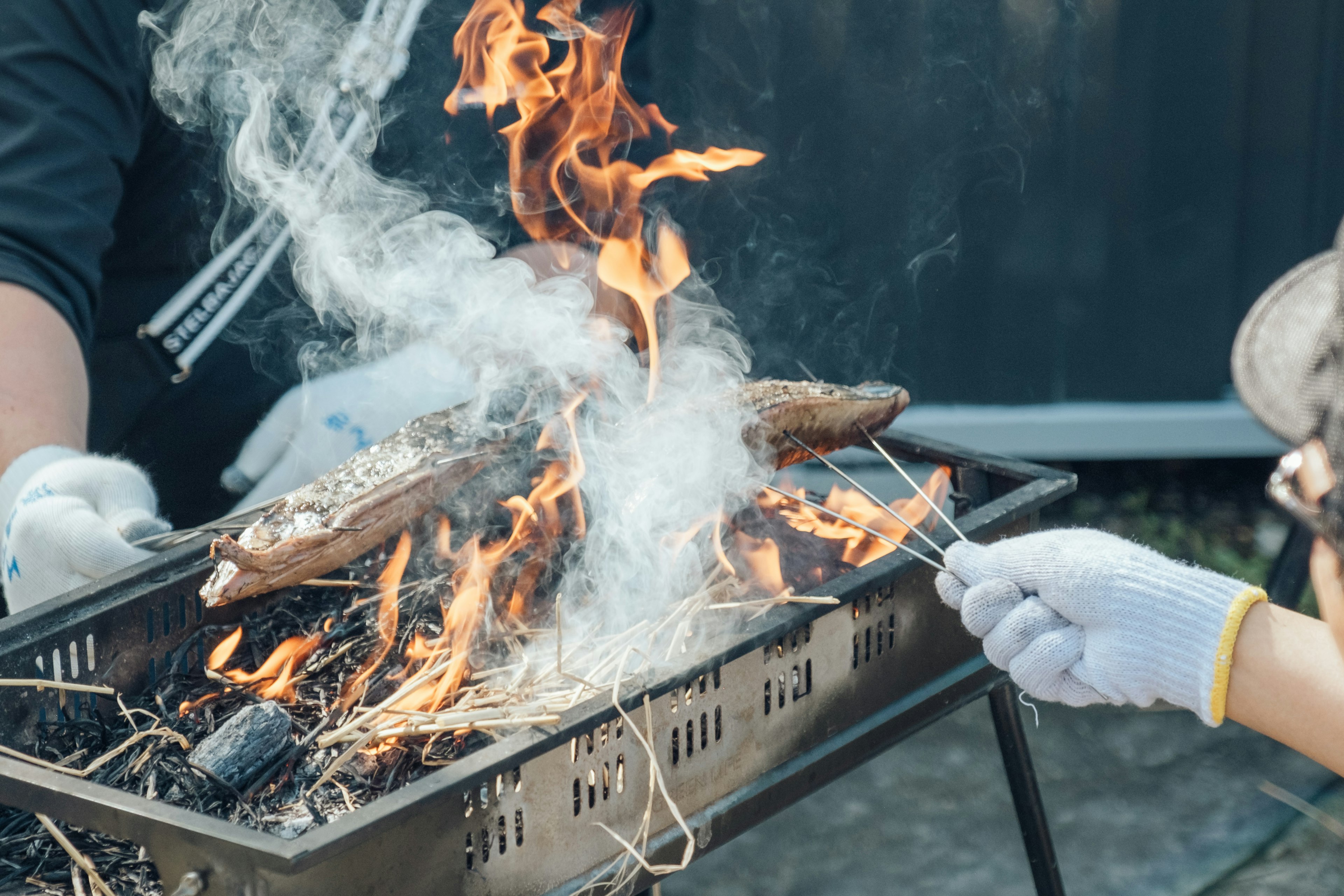 Fisch über offenem Feuer mit Rauch und Flamme grillen