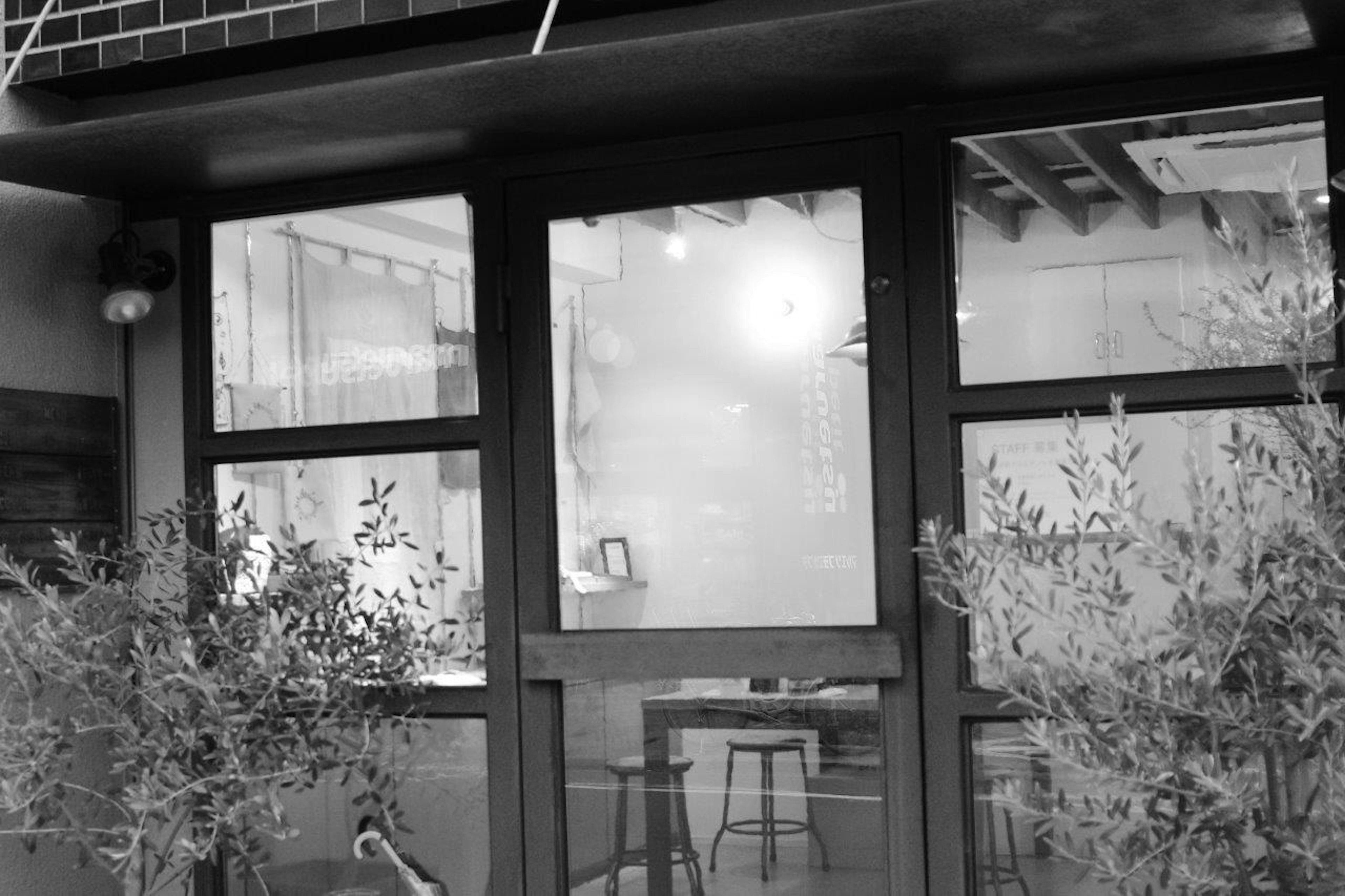 Black and white exterior of a café Simple interior visible through the windows