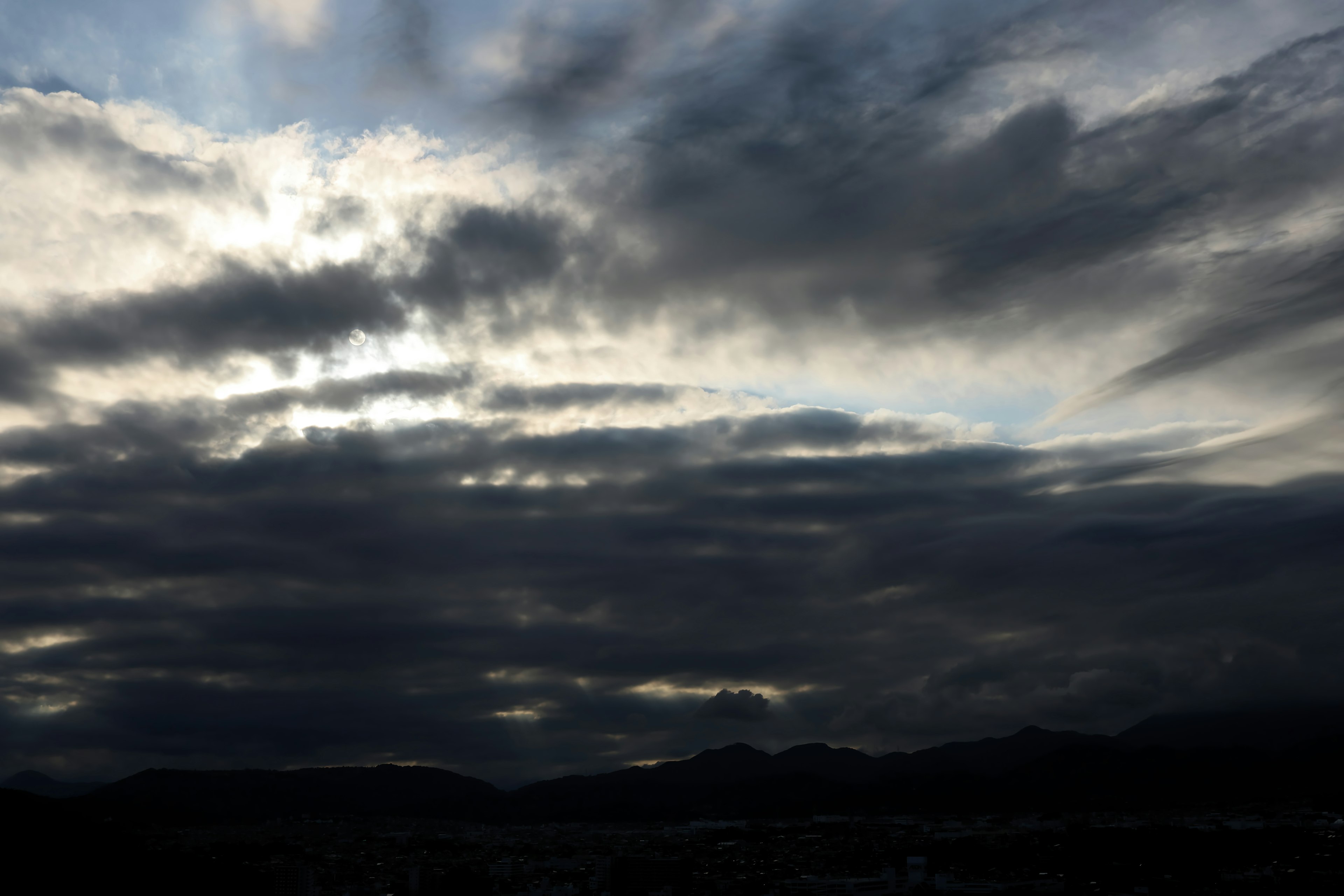 Dramatischer Himmel mit dunklen Wolken und Lichtstrahlen