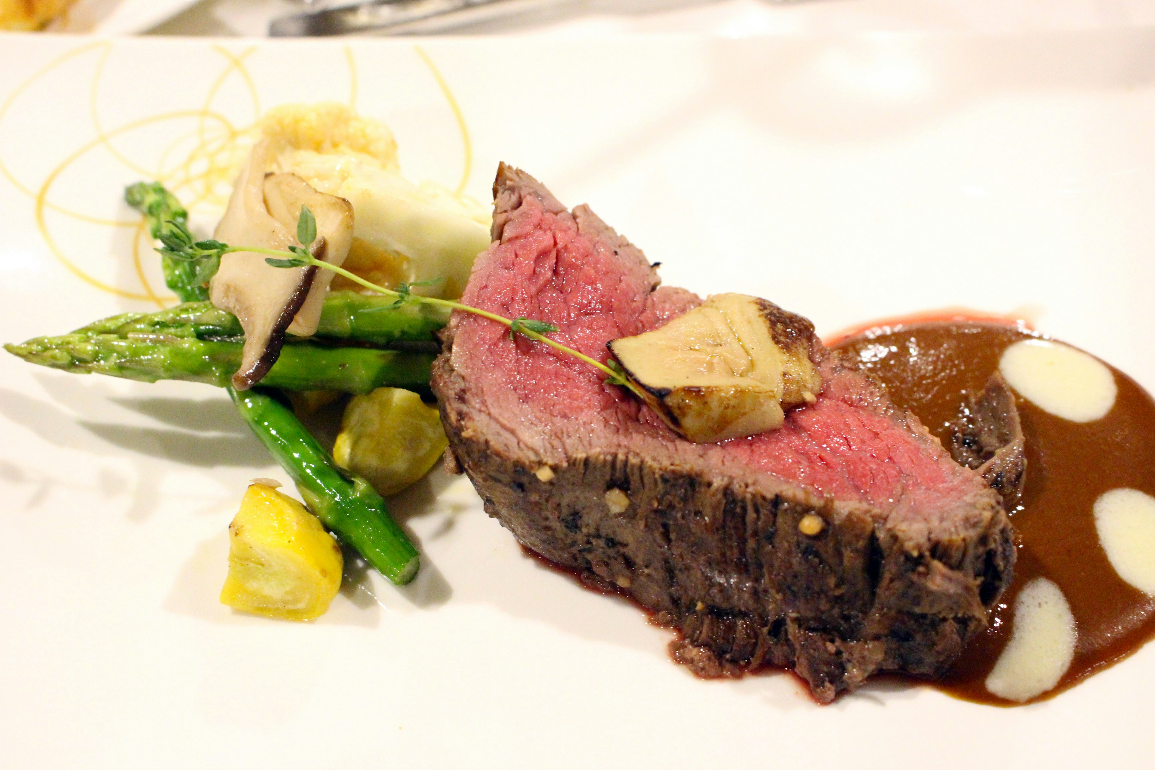 Serviertes Rindersteak mit Spargel und Gemüse