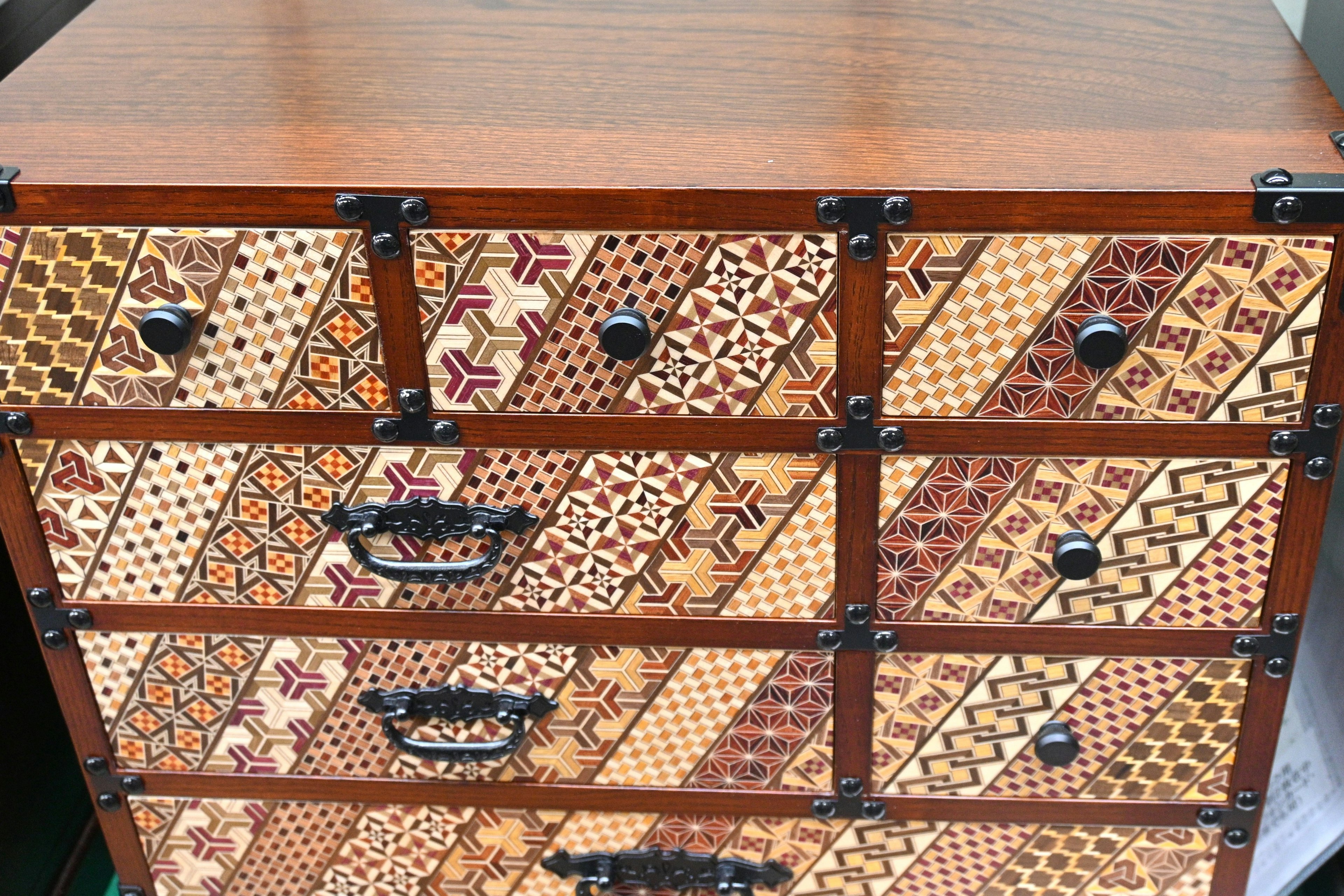 Wooden drawer cabinet featuring various decorative patterns