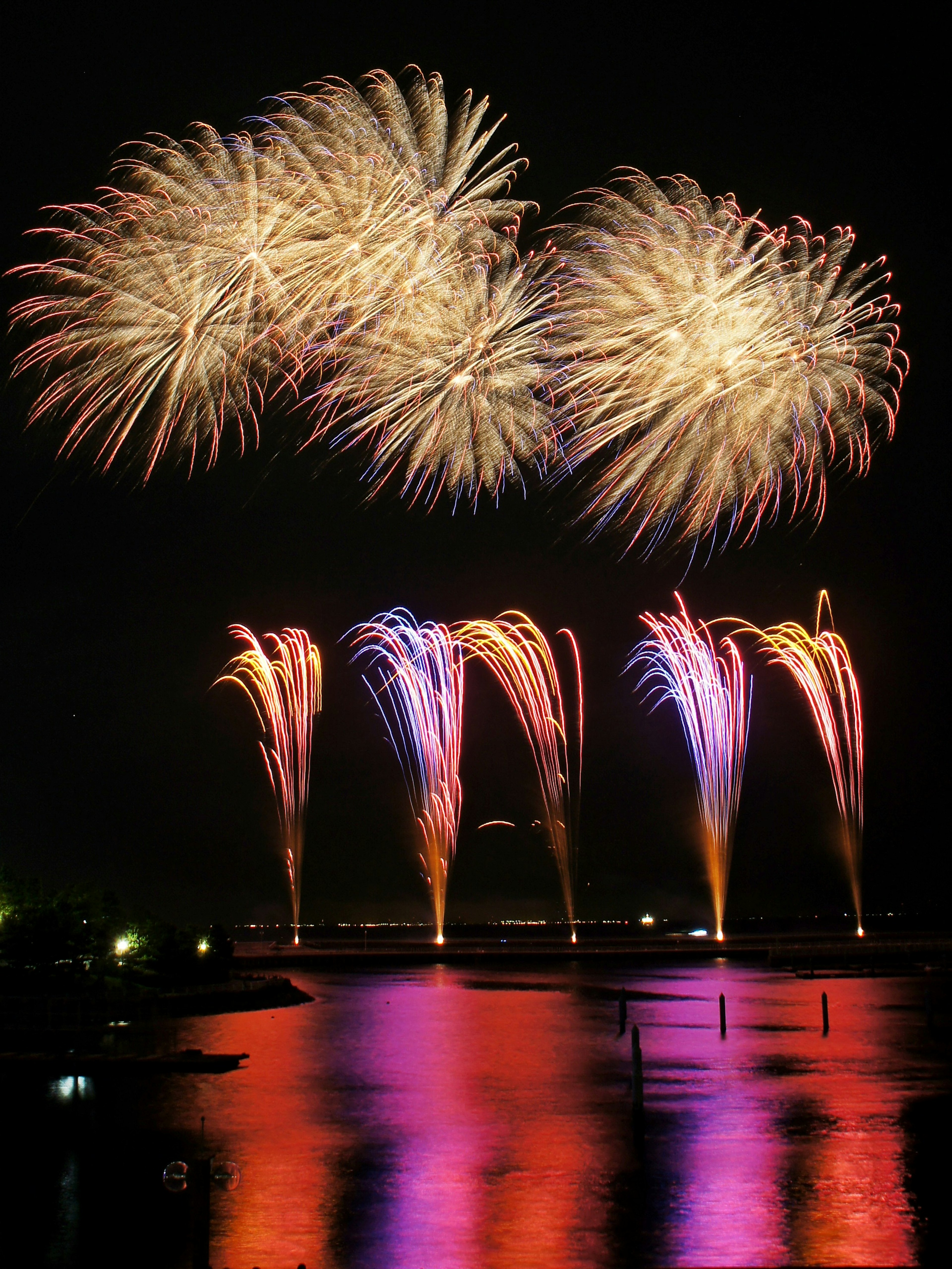 夜空中绽放的五彩烟花在水面上反射