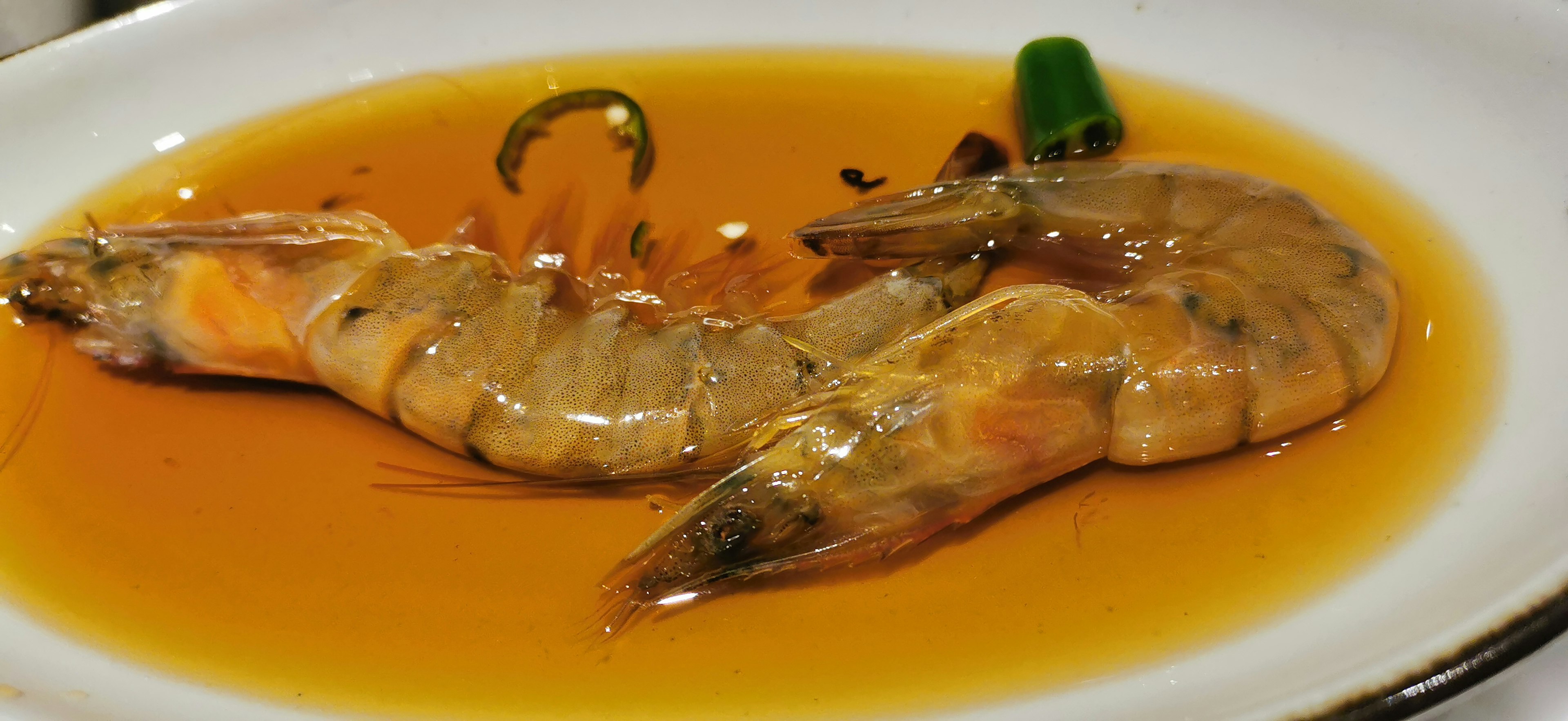 Large shrimp on a plate in sweet sauce