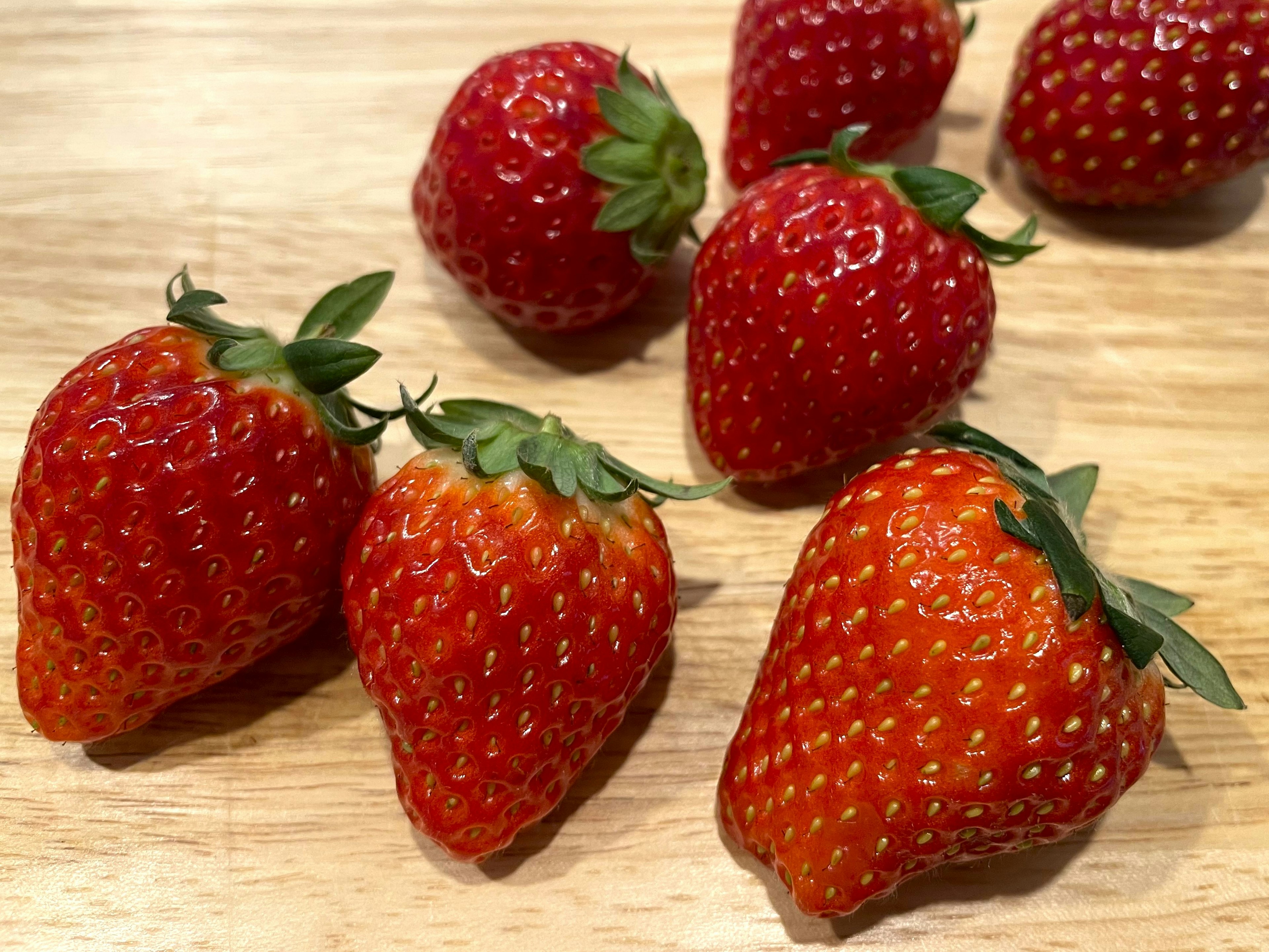 Fresh strawberries arranged on a wooden table