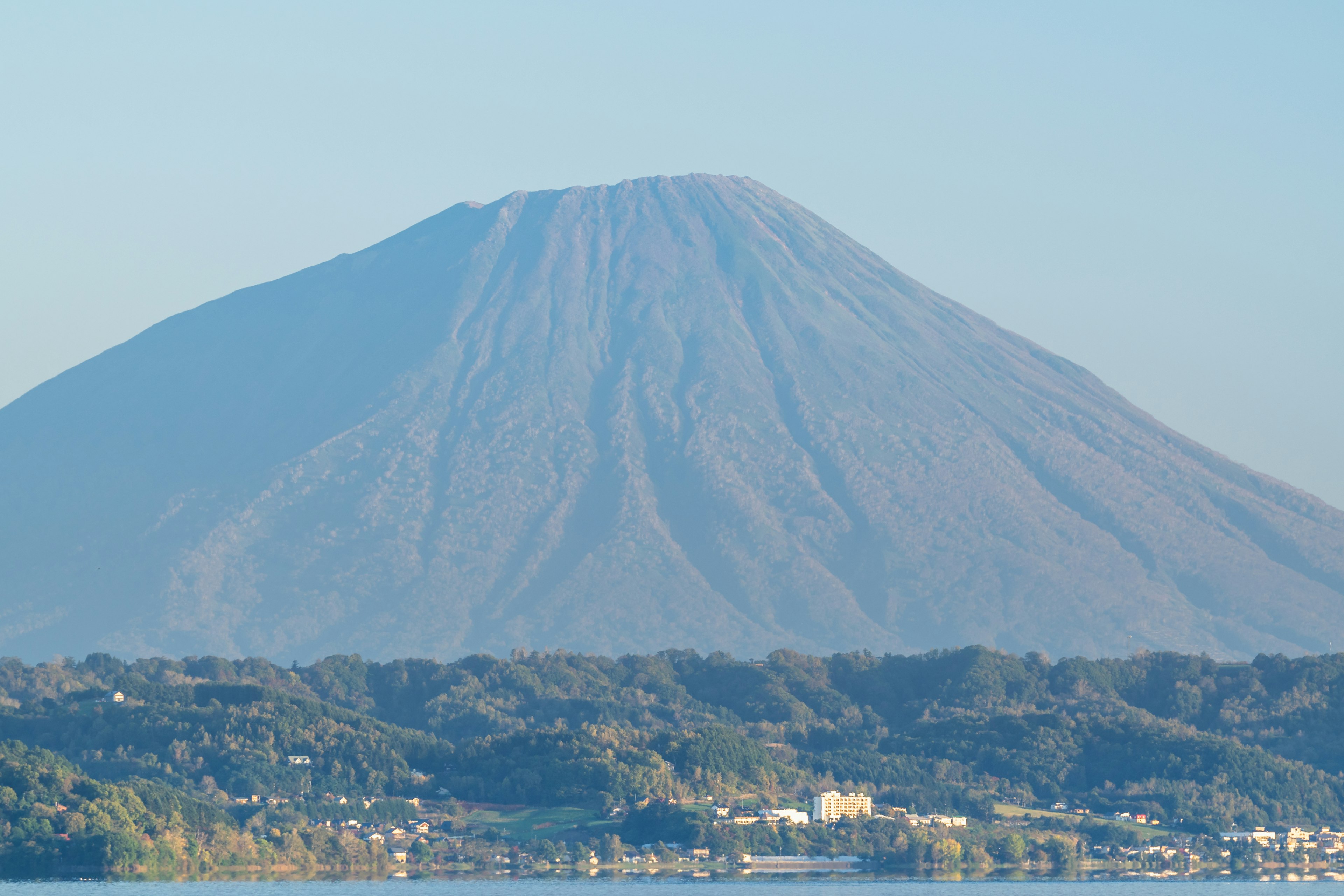 A stunning mountain landscape showcasing a majestic volcano under a blue sky