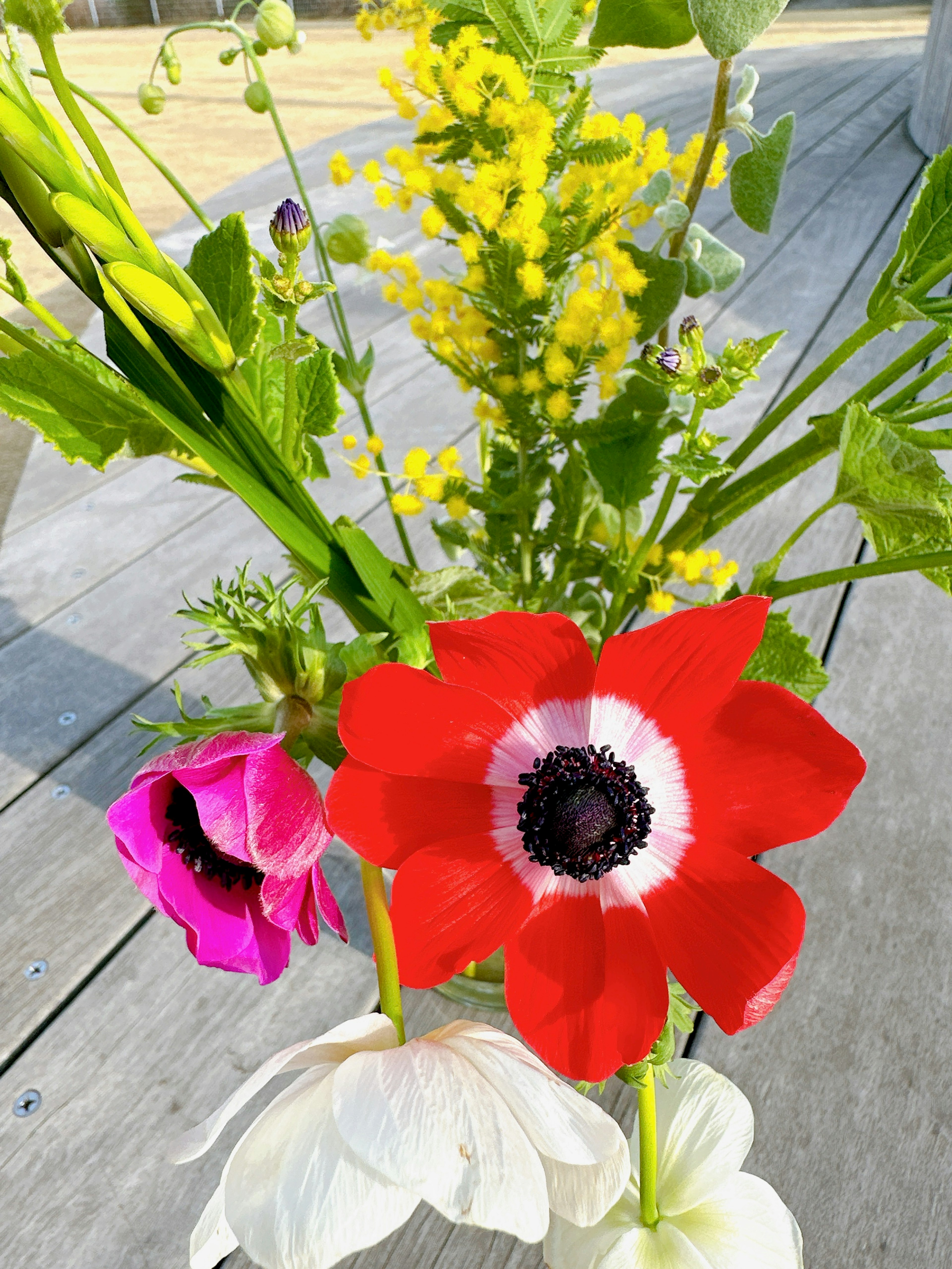 色とりどりの花々が生けられたアレンジメント赤いアネモネと白い花が目を引く