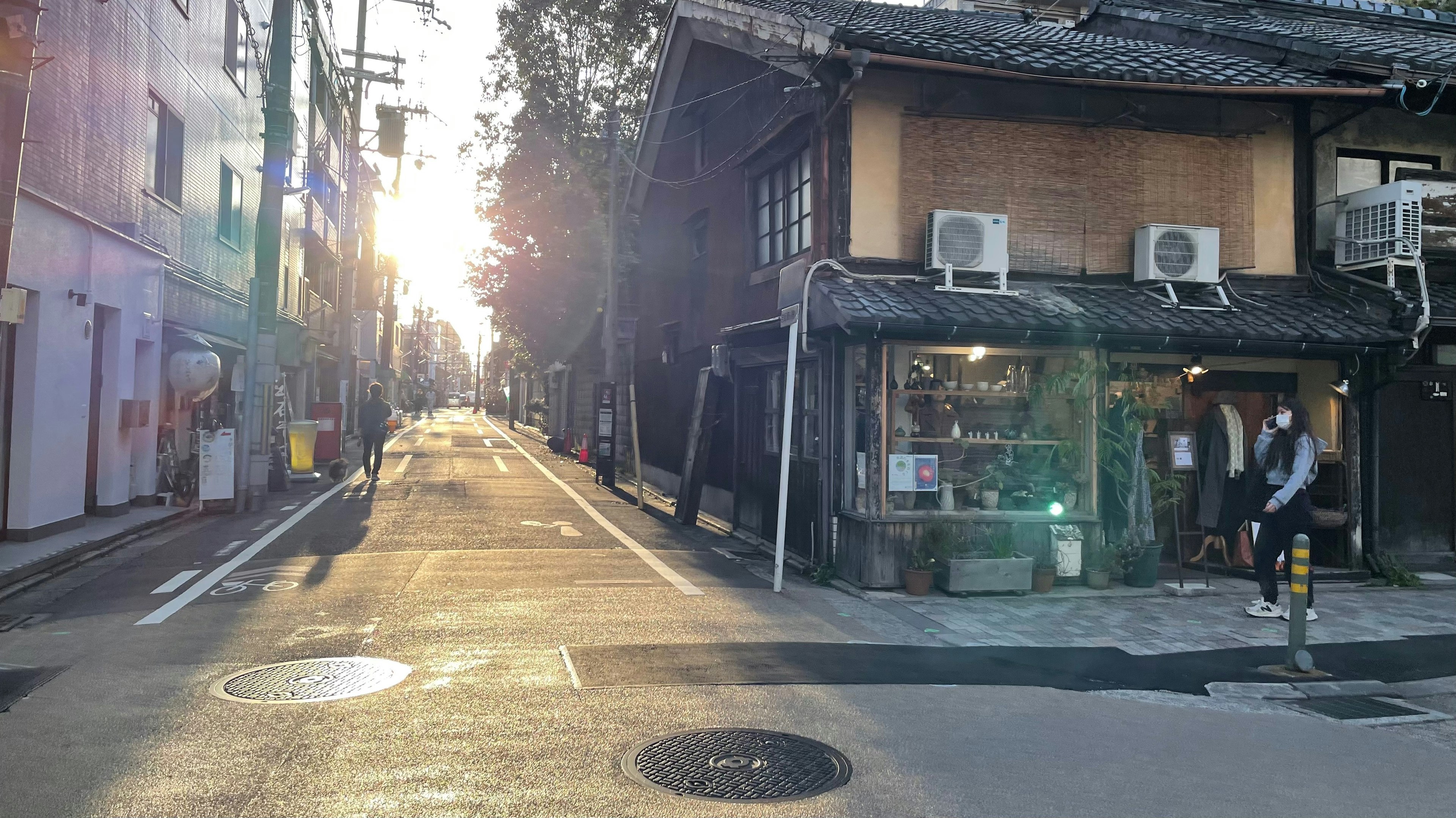 Scène de rue tranquille avec la lumière du soleil passant à travers des bâtiments japonais anciens et des boutiques modernes