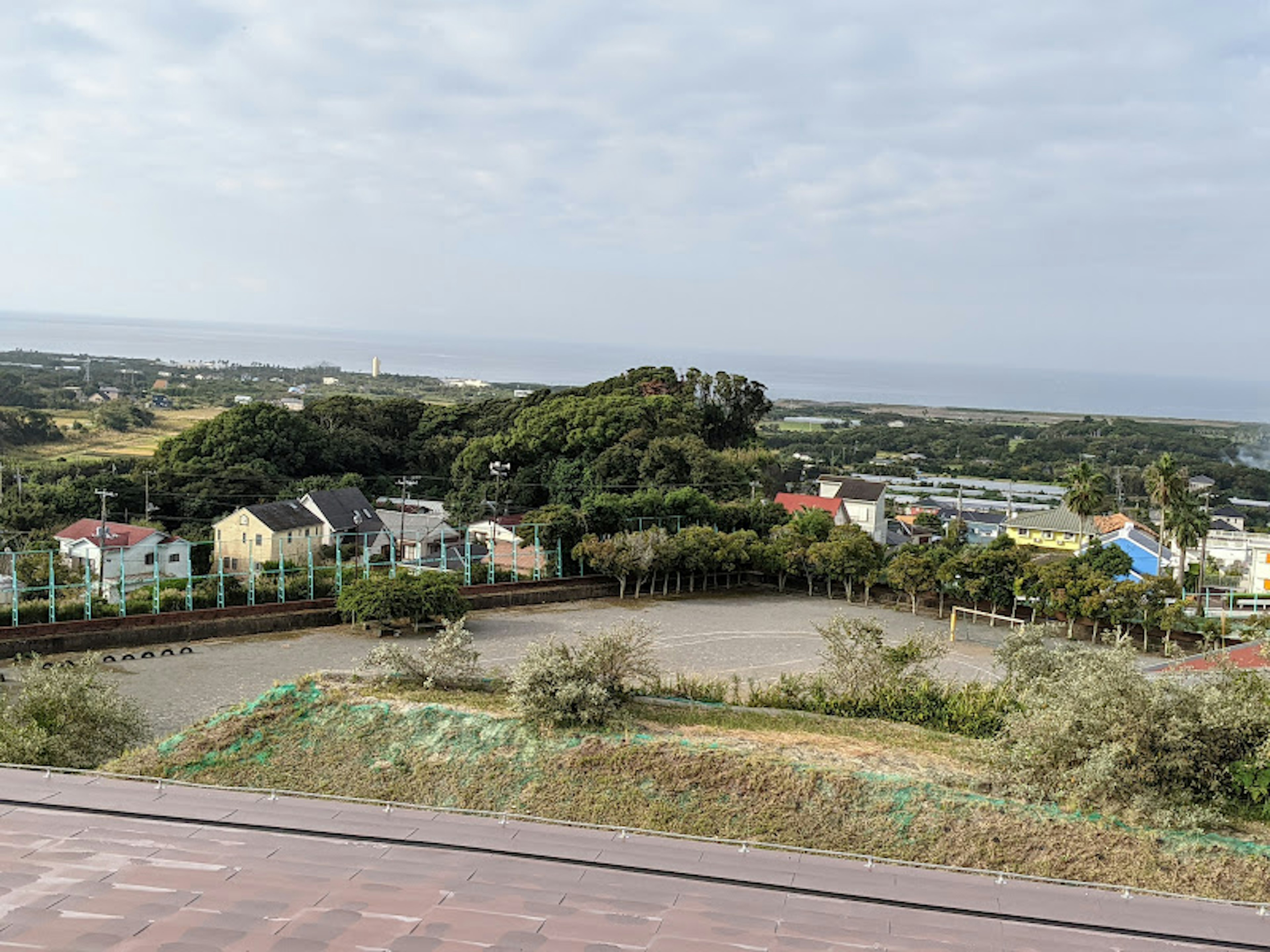 Scenic view from a hill overlooking colorful houses and the ocean in the distance