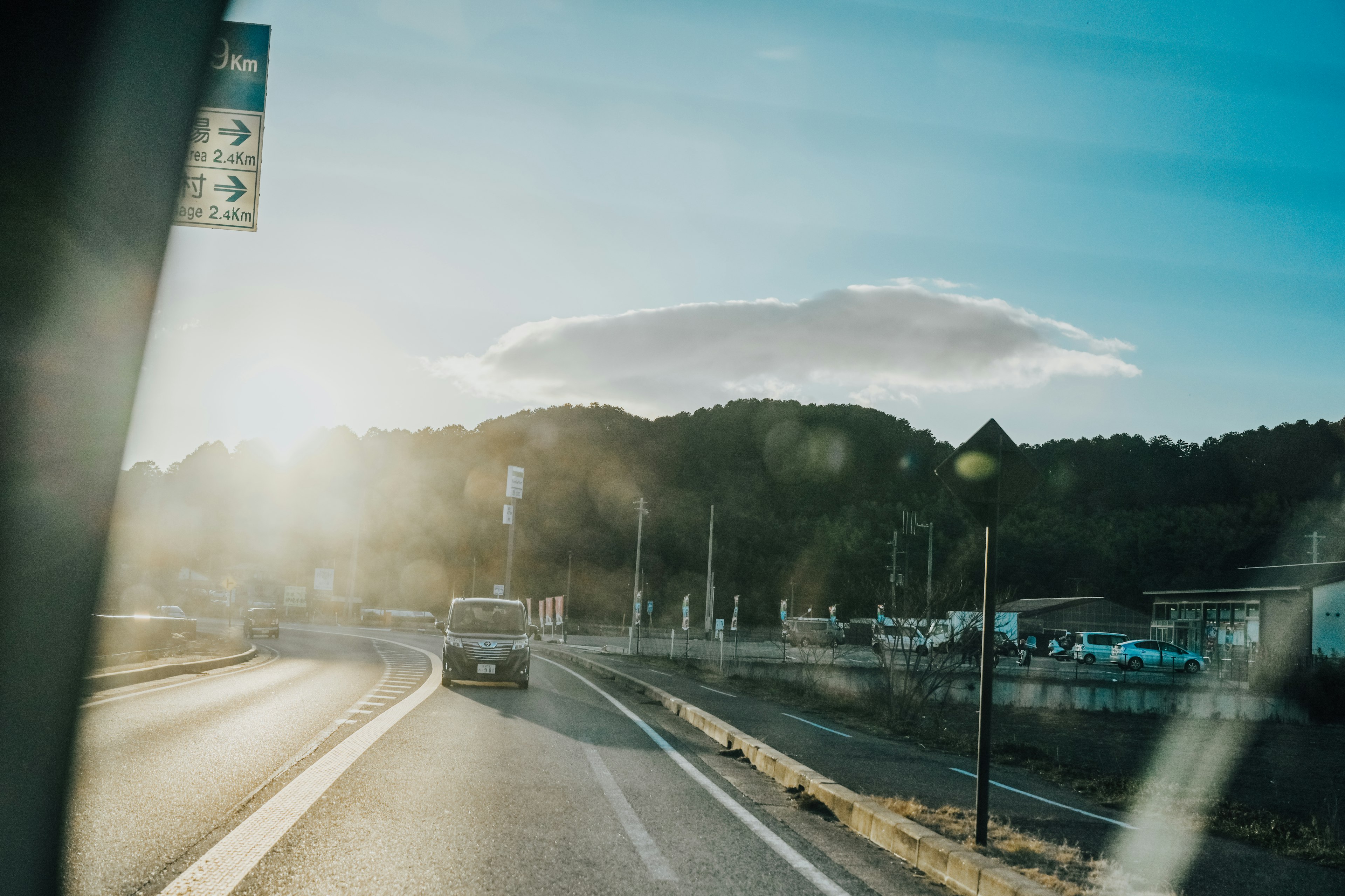 Scenic view of a road with a sunset and clouds in the background