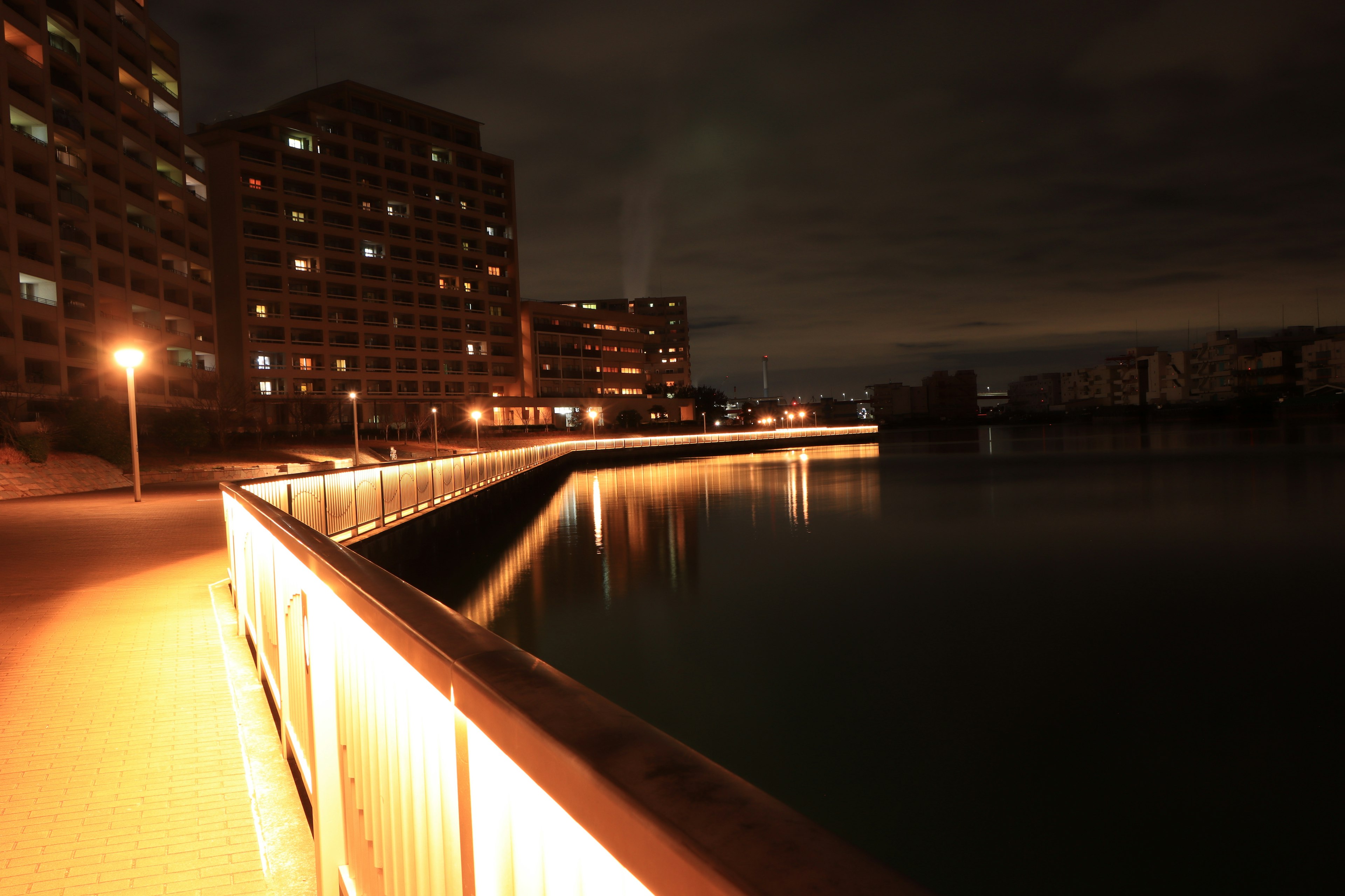 Vue nocturne d'une promenade en bord de mer avec des bâtiments éclairés