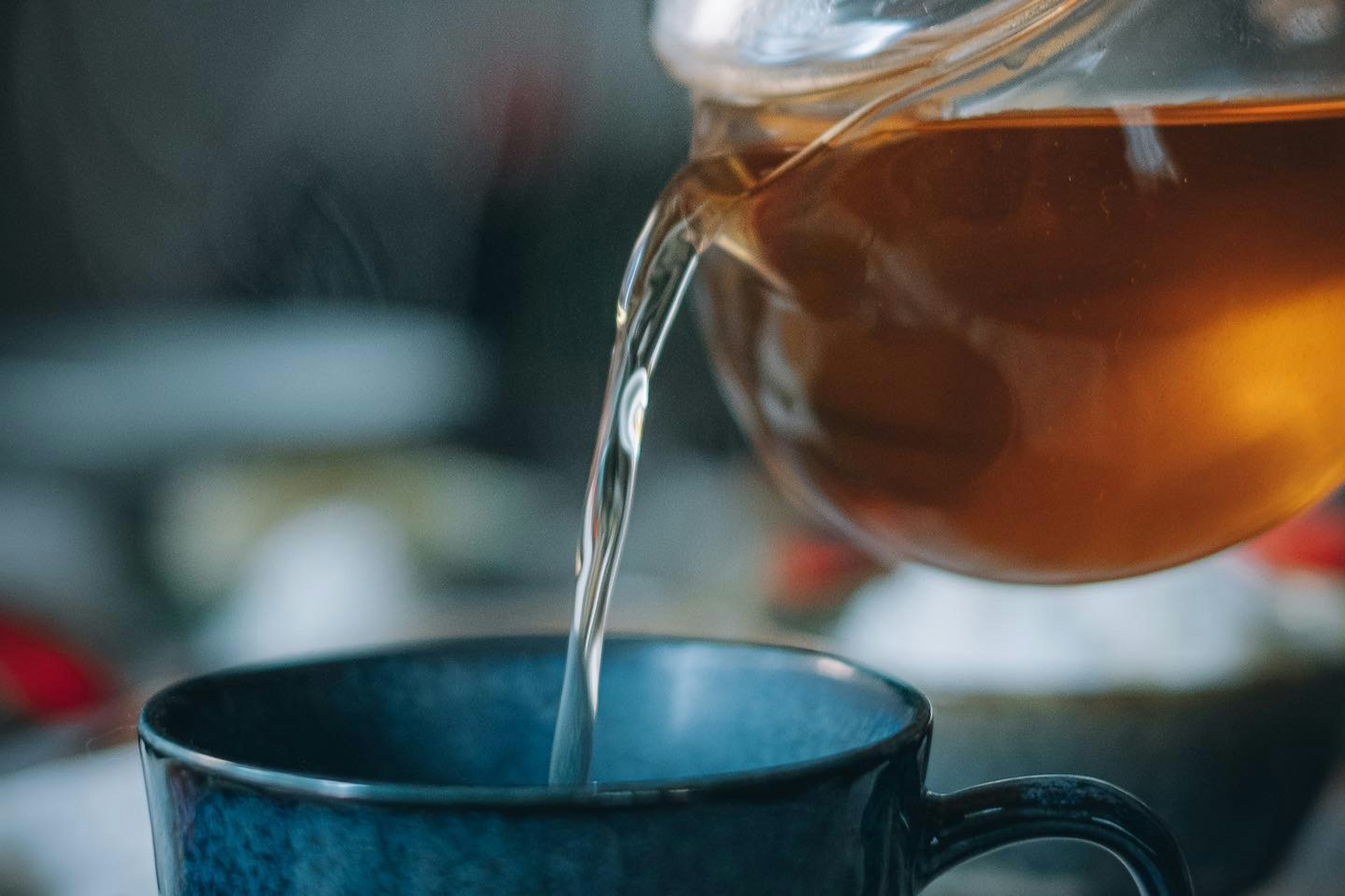 お茶が青いカップに注がれているシーン