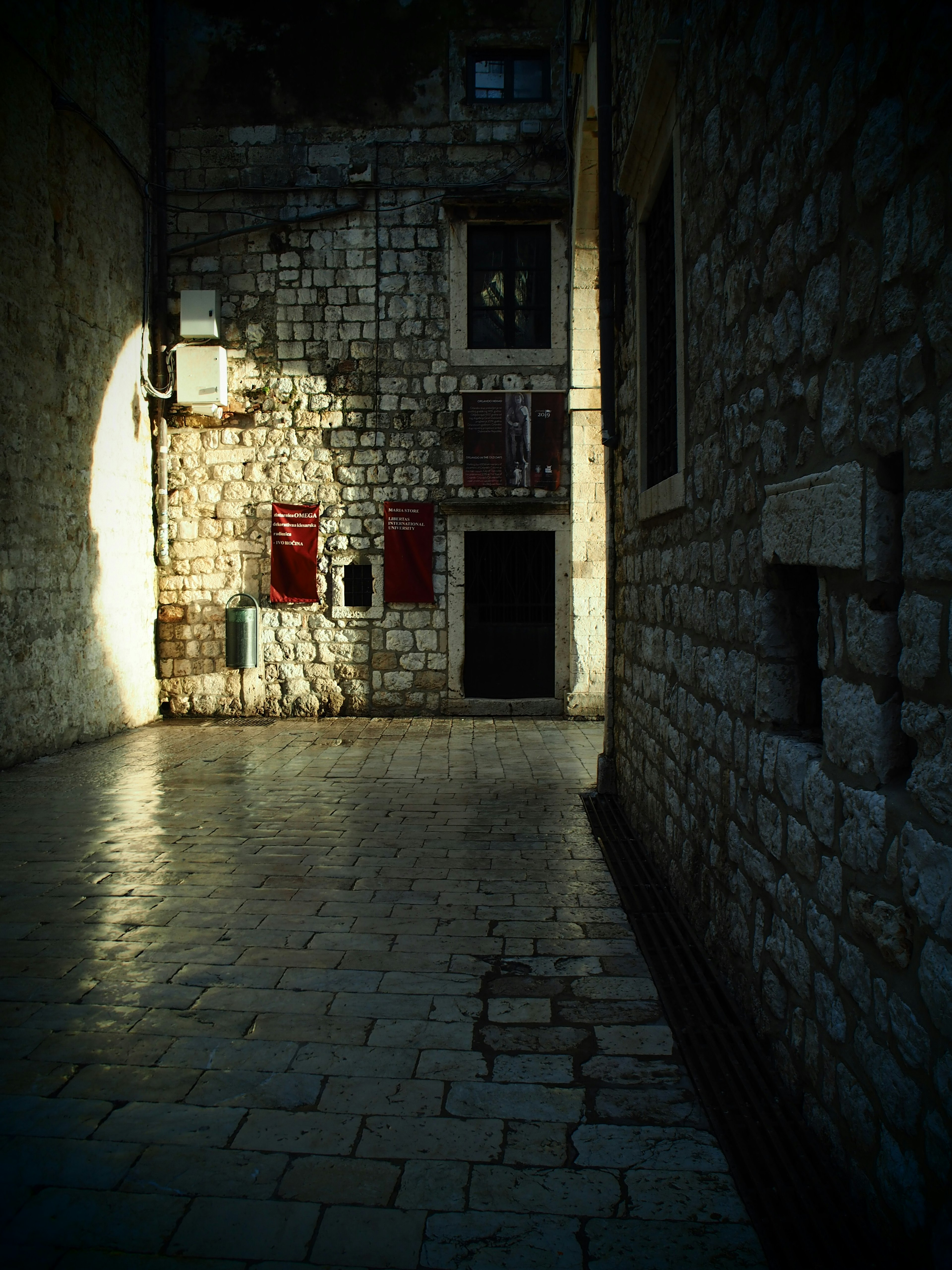 Ruhige Gasse mit Steinmauern und Schatten