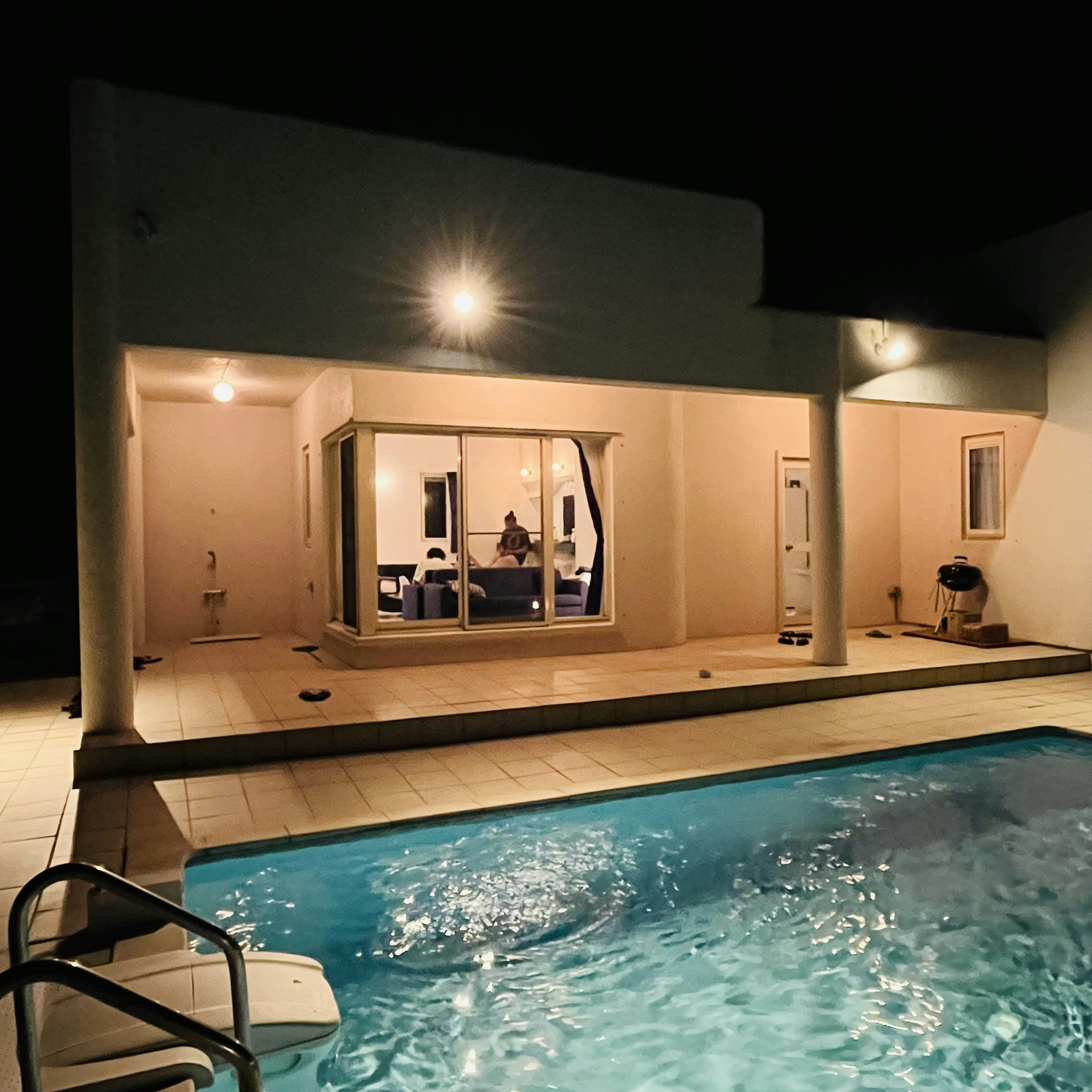 Exterior de una casa moderna con piscina de noche