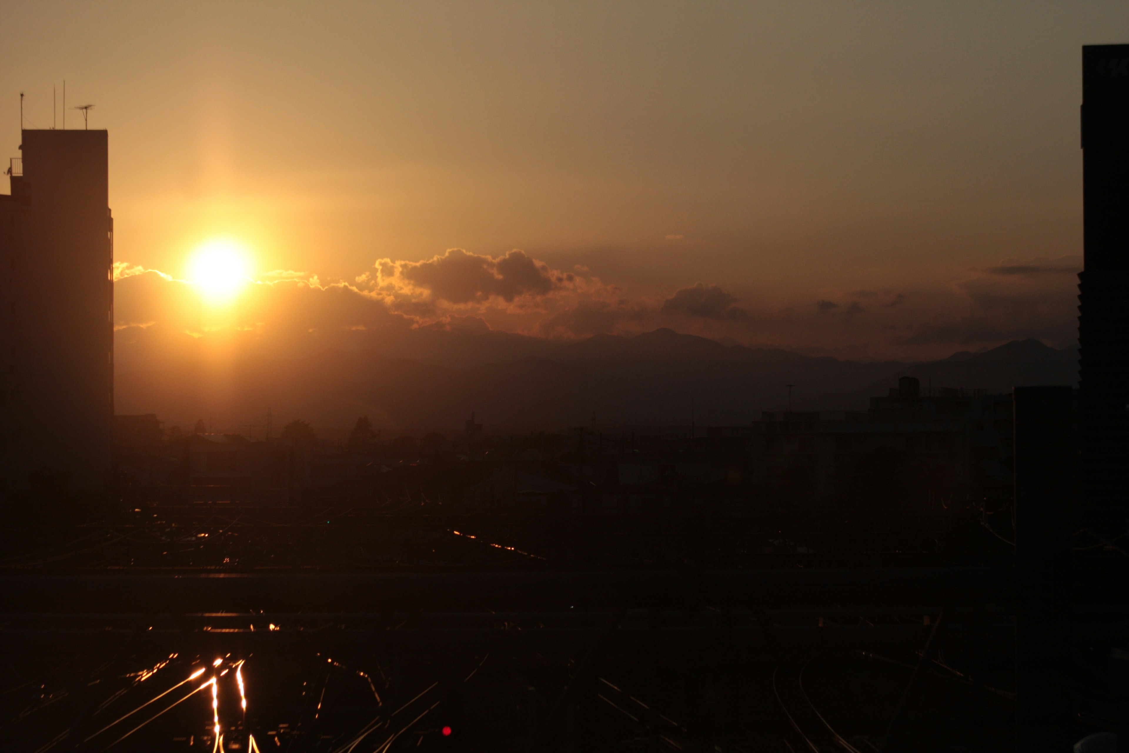 城市風景，夕陽在建築物之間落下