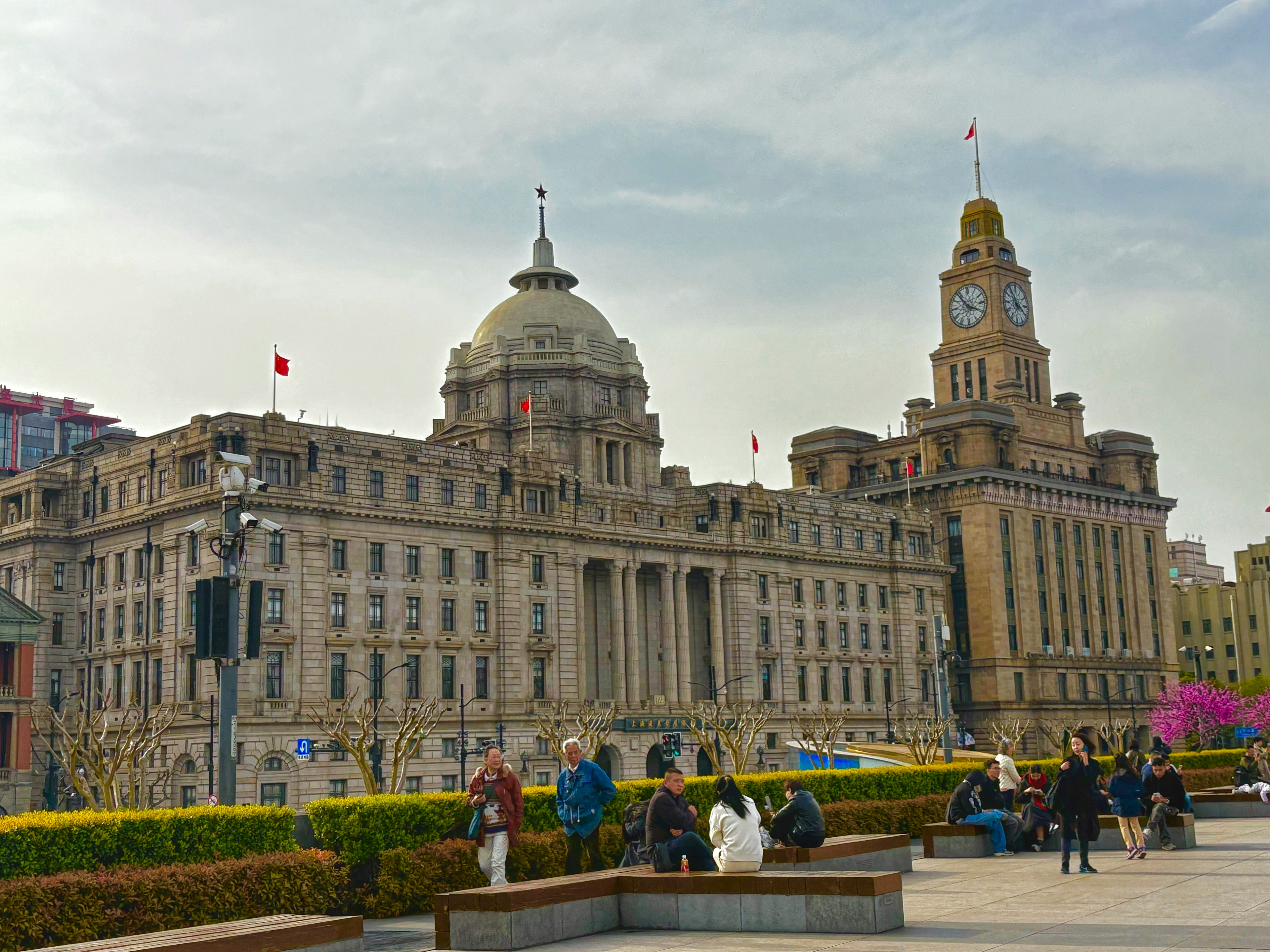 Bâtiments historiques au Bund à Shanghai avec des gens rassemblés sur la place