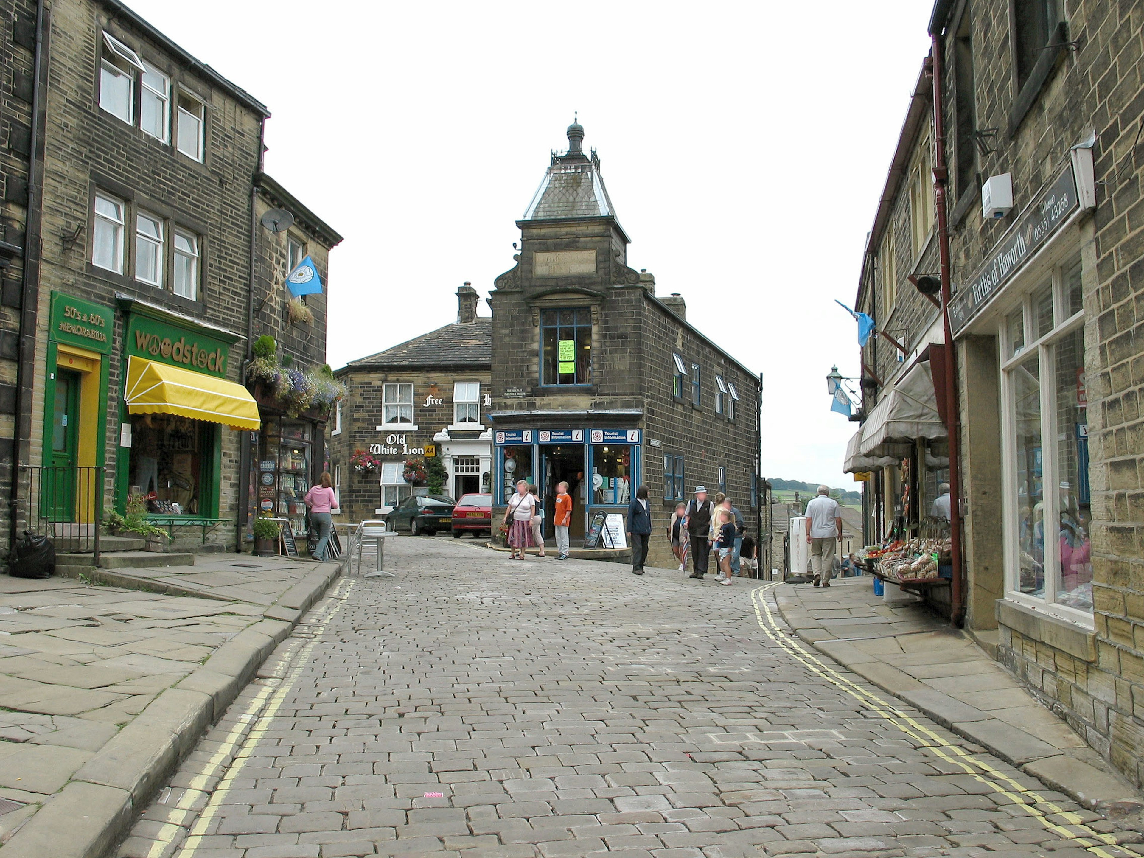 Quaint village street with cobblestones and shops colorful storefronts and people walking