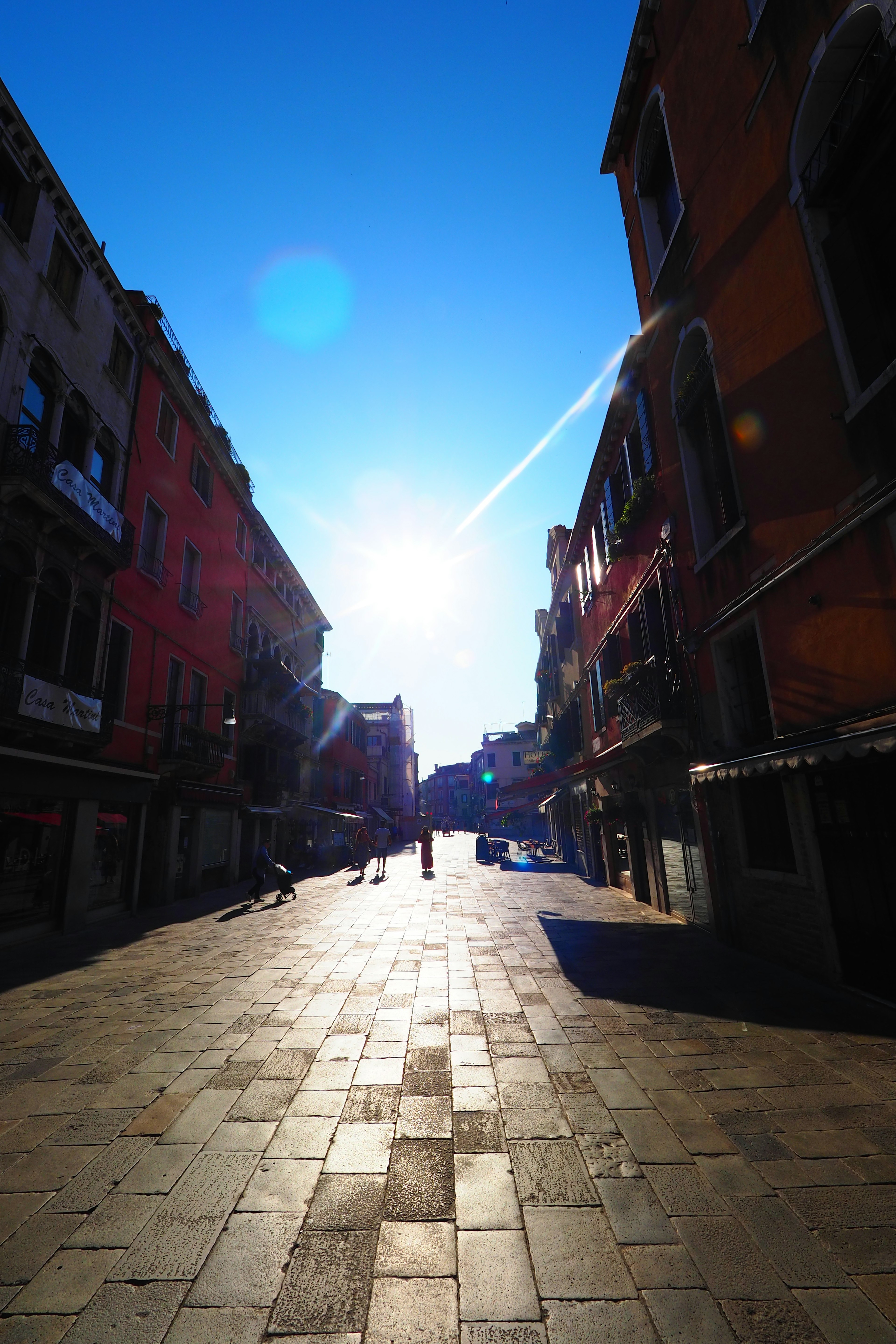 Ruhige Straße in Venedig unter einem hellblauen Himmel