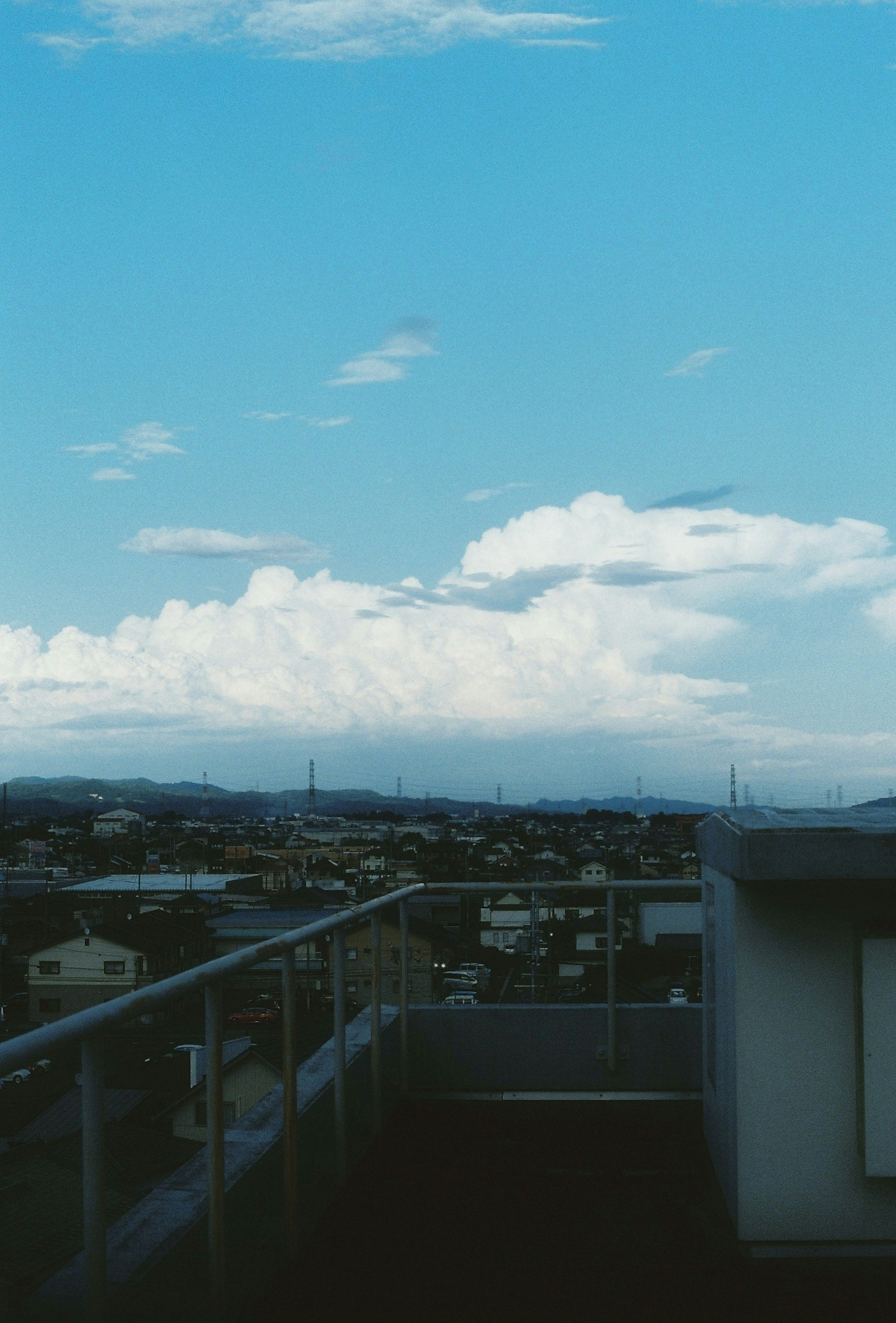 青空と雲の広がりを背景にした都市の風景